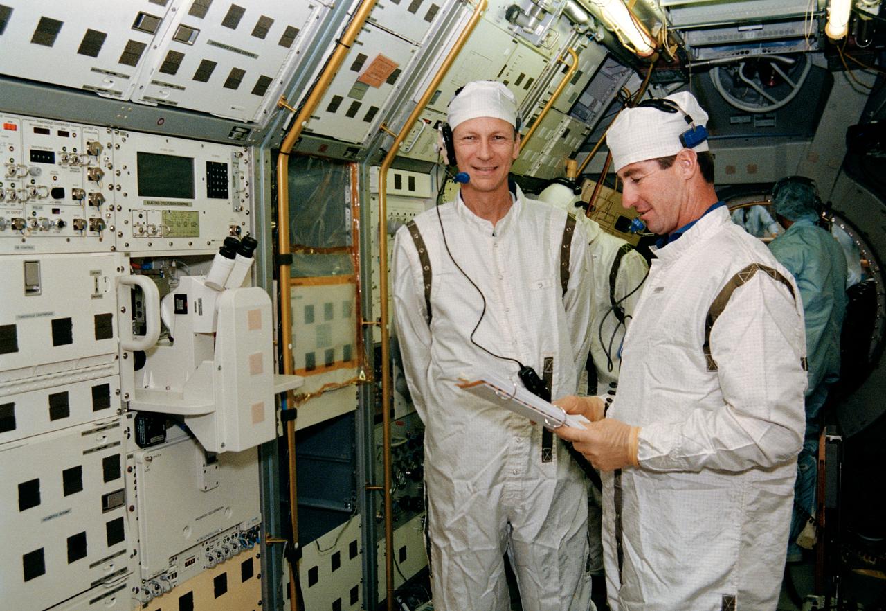 S93-29830 (4 Nov 1992) --- Inside the Spacelab D-2 module in the Operations and Checkout Building high bay, STS-55 Mission Commander Steven R. Nagel (left) and Pilot Terence T. Henricks are participating in a mission sequence test to check out experiment steps and procedures which will be conducted on-orbit. Spacelab D-2, the second German Spacelab, is scheduled to fly on space shuttle mission STS-55 in 1993.