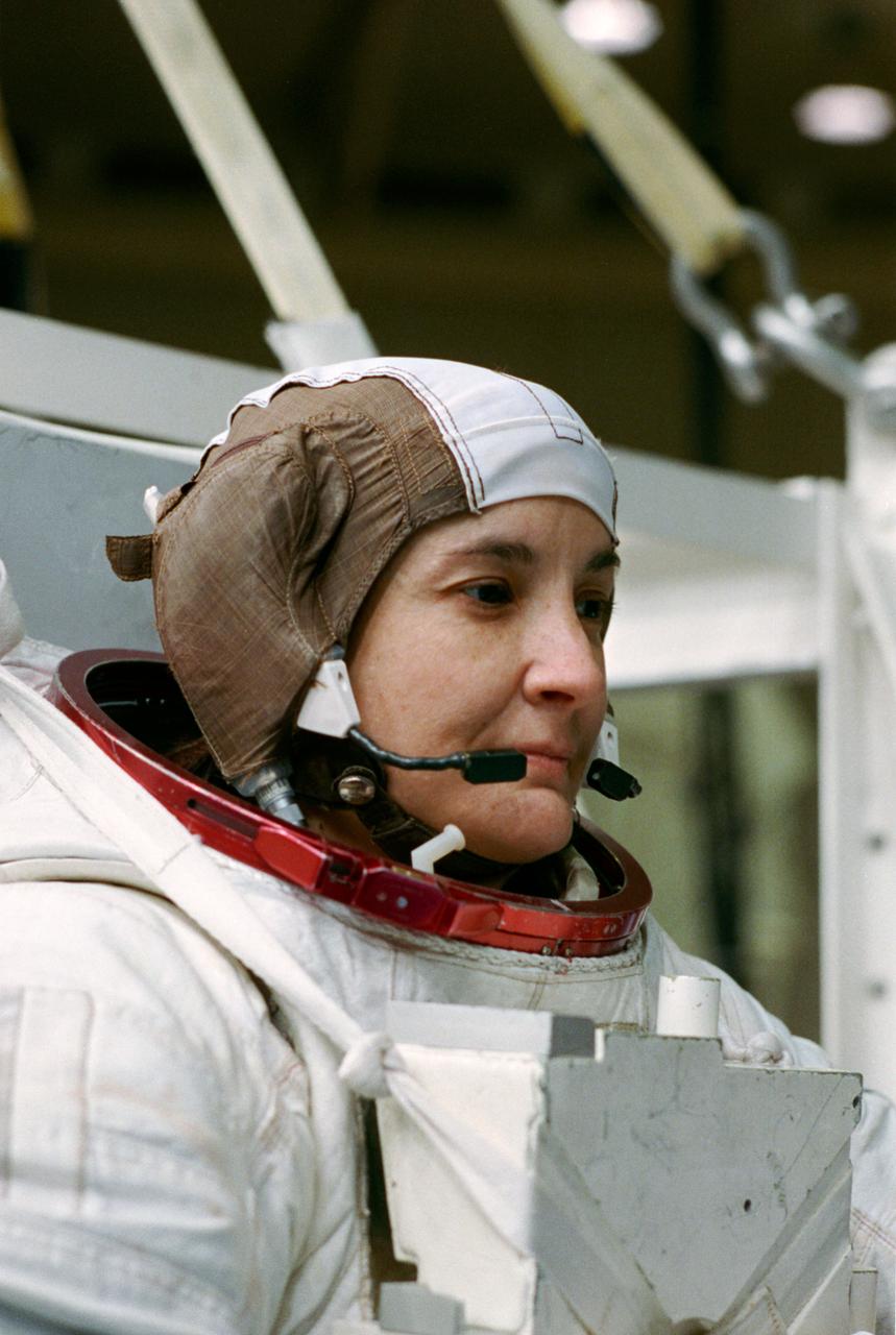 S93-41572 (17 Aug 1993) --- Astronaut Linda M. Godwin, payload commander, prepares to donn her helmet before being submerged in a 25-feet deep pool at the Johnson Space Center's (JSC) Weightless Environment Training Facility (WET-F).  Astronauts Godwin and Thomas D. Jones, mission specialist, are using the WET-F to train for contingency space walks for their Space Shuttle Endeavour mission next year.  No space walks are planned for the flight.