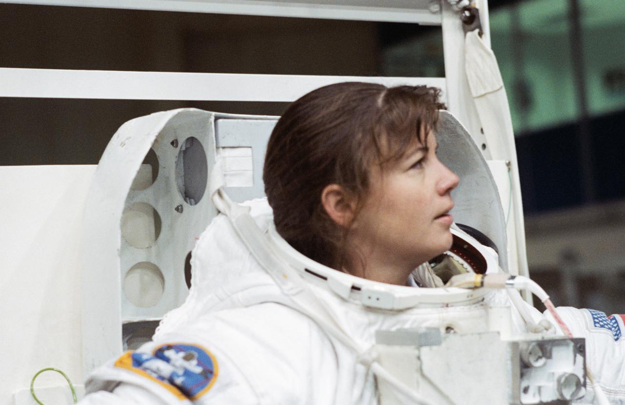 S93-42453 (September 1993) --- Astronaut Catherine G. Coleman, mission specialist for STS-73, is about to don the helmet portion of a high-fidelity training version of an Extravehicular Mobility Unit (EMU) space suit at the Johnson Space Center?s (JSC) Weightless Environment Training Facility (WET-F).  Coleman, who has recently been named as one of seven crew members for the U.S. Microgravity Laboratory (USML-2) mission, was about to go underwater in a 25-feet deep pool.  The pool is used to train astronauts for mission specific space walk chores as well as for contingency Extravehicular Activity (EVA) tasks.  There is no space walk planned for STS-73.