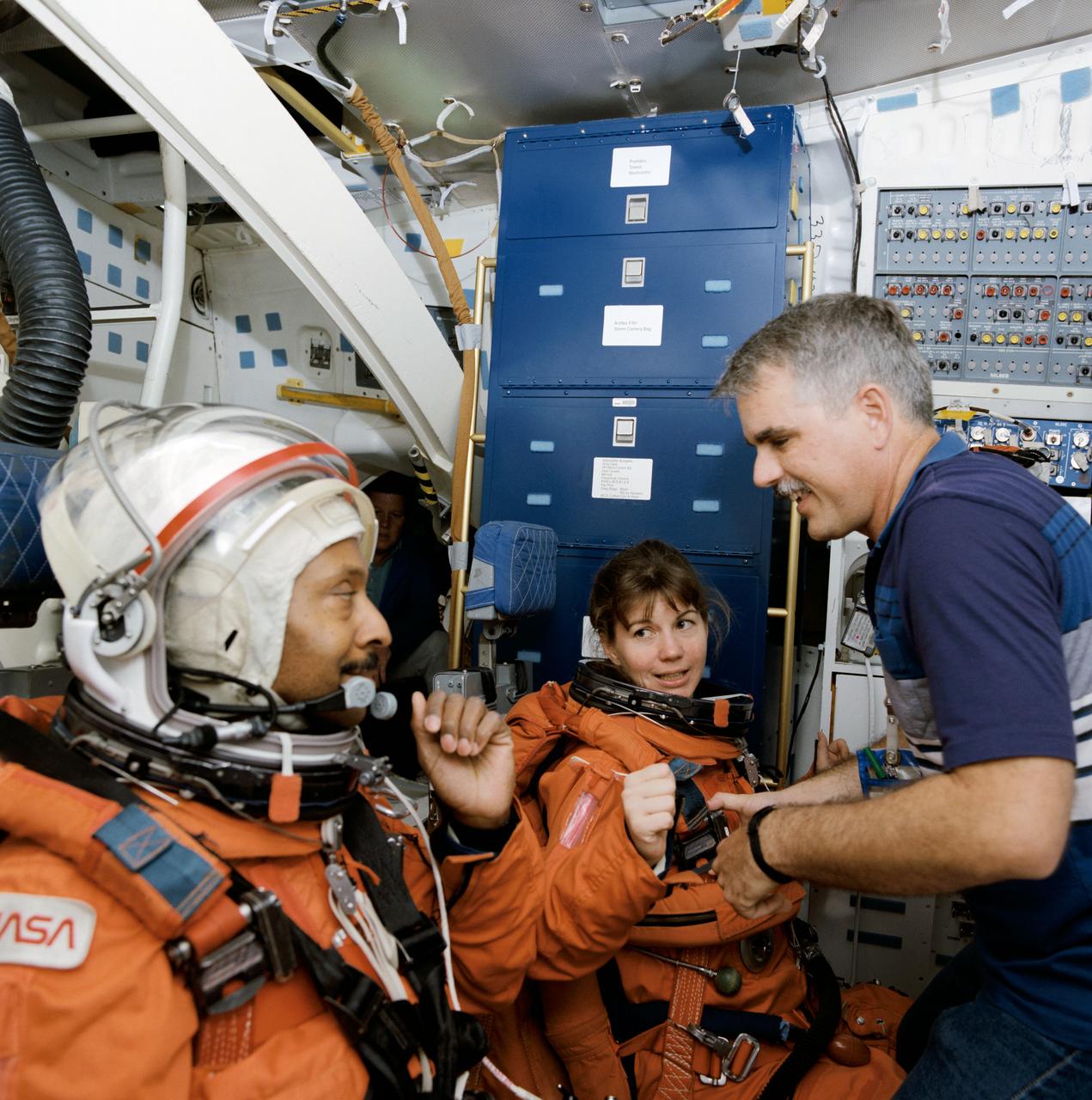 S94-33189 (June 1994) --- Though they have been assigned to two different missions, two NASA astronauts share a briefing about a common mission phase of activity - ascent. Winston E. Scott and Catherine G. Coleman, mission specialists for STS-72 and 73 respectively are briefed by John Hopkins in the mid-deck of one of two full-scale trainers in Johnson Space Center?s (JSC) Systems Integration Facility. Both mission specialists are seated in special break-down stations that accommodate a portion of each Shuttle crew during ascent and entry phases of the flight.