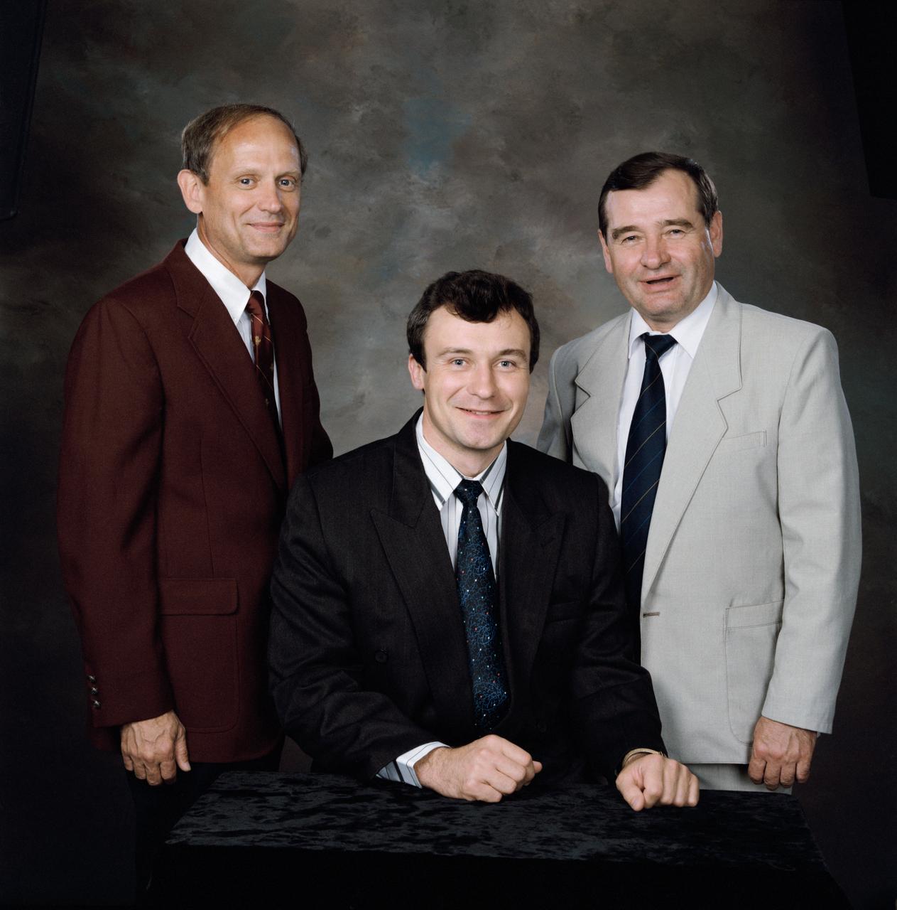 This is a portrait of the Mir 18 crew members in civilian clothes. They are (left to right) Norman E. Thagard, astronaut; commander Vladimir N. Dezhurov, cosmonaut; and Gennadiy M. Strekalov, cosmonaut.