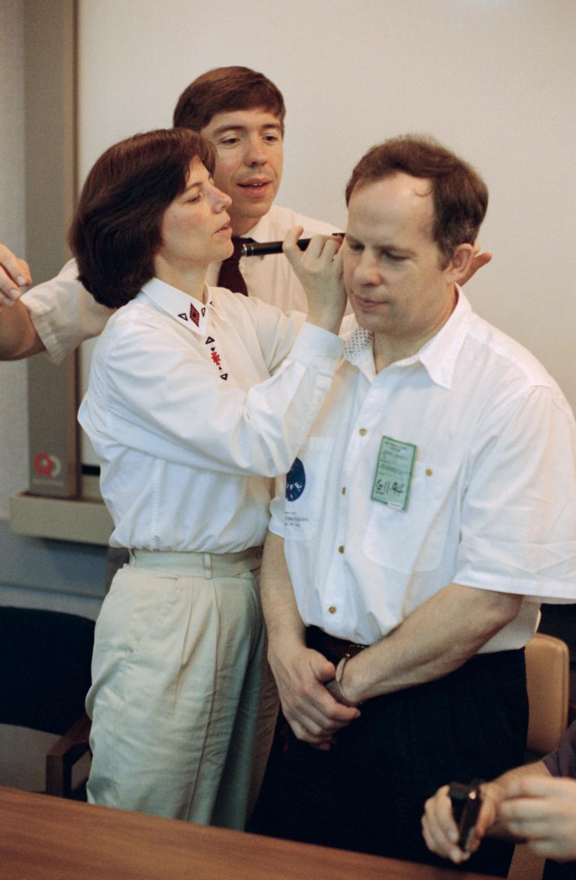 S94-35071 (17 June 1994) --- Flight surgeon Mike Barrett looks on as astronaut Bonnie J. Dunbar conducts a physical examination on cosmonaut Anatoly Solovyov.  Crew members for the joint Space Shuttle/Mir missions are in the midst of three weeks' medical operations training for their cooperative flights.