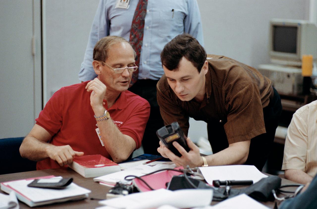 Mir 18 commander Vladimir N. Dezhurov, right, and fellow crew member, astronaut Norman E. Thagard, practice using a bar-code reader during medical operations training at JSC.