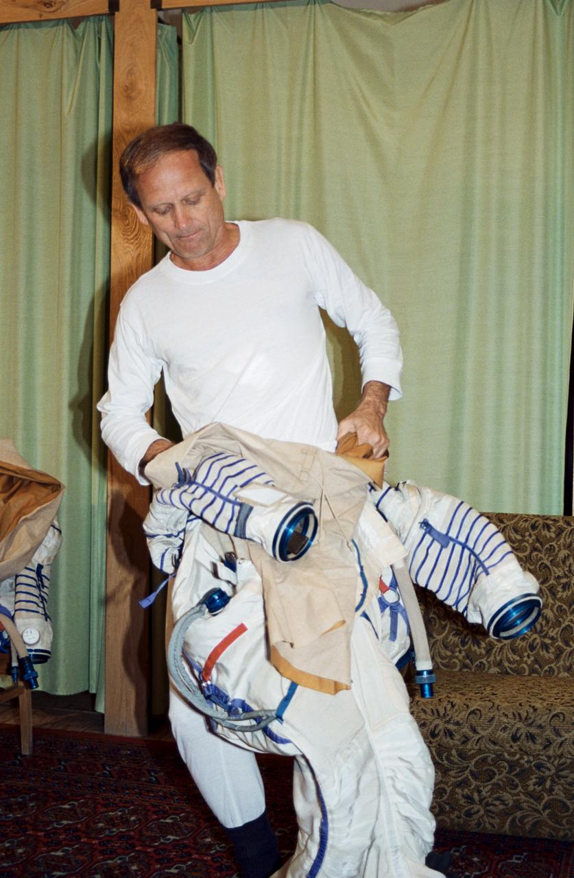 Astronaut Norman E. Thagard getting into a cosmonaut space suit in the Training Simulator Facility at the Gagarin Cosmonaut Training Center (Star City), near Moscow, Russia.