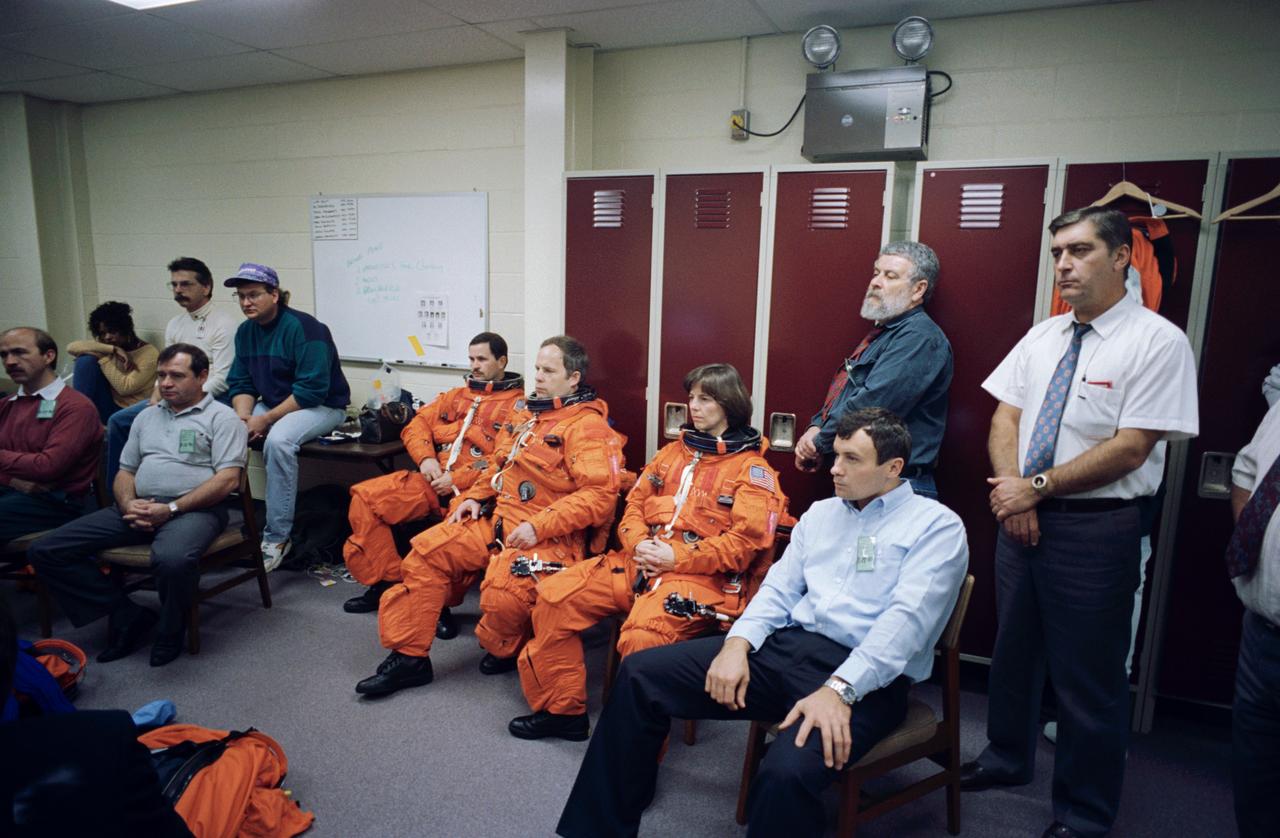 S94-47218 (28 Oct 1994) --- A number of Russian cosmonauts and an American astronaut listen to a briefing on launch and landing emergency situations during a training session in the Systems Integration Facility at the Johnson Space Center (JSC).  Scheduled to launch aboard the Space Shuttle Atlantis with the STS-71 crew (in orange suits, left to right) are Nikolai M. Budarin, Mir 19 flight engineer; Anatoliy Y. Solovyev, Mir 19 mission commander; and Bonnie J. Dunbar, STS-71 mission specialist.  The three are flanked by cosmonauts Gennadiy M. Strekalov (seated, second left) and Vladimir N. Dezhurov (seated, right foreground), flight engineer and commander, respectively, for the Mir-18 mission, who will return from a Russian Mir Space Station stay in Atlantis along with the two-way crew members of the STS-71 mission.  Alexsandr F. Poleshchuk (seated, far left) is a Mir-reserve crew member.