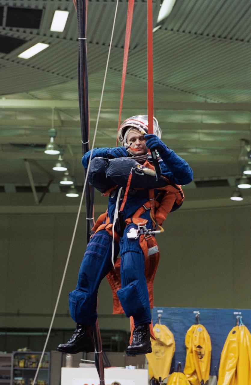 S94-47232 (13 Oct 1994) --- Cosmonaut Yuriy I. Onufriyenko (right), in the United States to participate in training for joint Russia-United States space missions, simulates a parachute drop into water. The training took place in the Johnson Space Center's (JSC) Weightless Environment Training Facility (WET-F) because it contains a 25-feet-deep pool. Onufriyenko, a Mir reserve team member, and a number of other cosmonauts and astronauts participating in the joint program were in Houston, Texas to prepare for upcoming missions which involve crewmembers from the two nations.