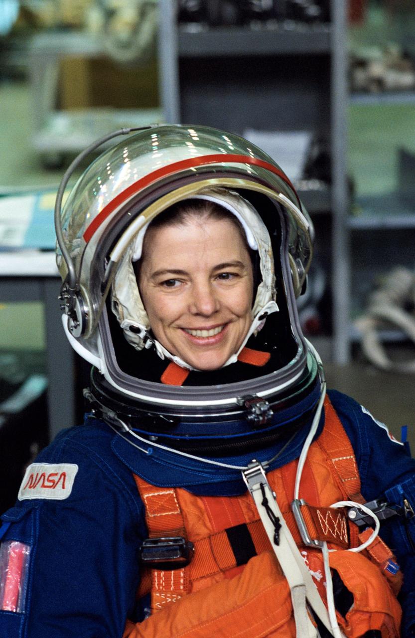S94-47256 (13 Oct 1994) --- Astronaut Bonnie J. Dunbar, STS-71 mission specialist, smiles as she watches a crew mate (out of frame) make a simulated parachute landing in nearby water. The action came as part of an emergency bailout training session in the Johnson Space Center's (JSC) Weightless Environment Training Facility's (WET-F) 25-feet-deep pool.