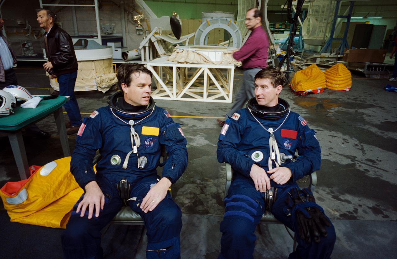S95-03470 (16 FEB 1995) --- Attired in blue training versions of the orange Shuttle launch and entry garments, astronauts Terence T. (Tom) Henricks, right, and Kevin R. Kregel take a break during a bailout training session at the Johnson Space Center's (JSC) Weightless Environment Training Facility (WET-F).  Assigned as commander and pilot, respectively, for the STS-70 mission, the two later joined their crew mates in making use of a nearby 25-feet deep pool to practice parachute landings in water and subsequent deployment of life rafts.