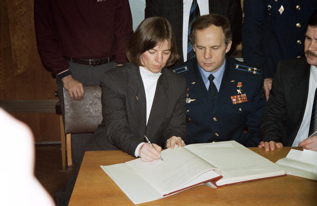 S95-04325 (22 March 1995) --- In keeping with Russian tradition, astronaut Bonnie J. Dunbar (left), STS-71 mission specialist, signs the diary of the late Yuriy A. Gagarin, the first Russian cosmonaut, as her STS-71 crew mates look on.  Cosmonauts Anatoliy Y. Solovyov (center), Mir 19 mission commander, and Nikiolai M. Budarin, flight engineer, have been training with Dunbar in both the United States and Russia for the past several months.  It is customary for each crew member about to aboard a Russian spacecraft to sign the diary.  Dunbar has been in Russia training as alternate researcher for the Mir 18 mission.