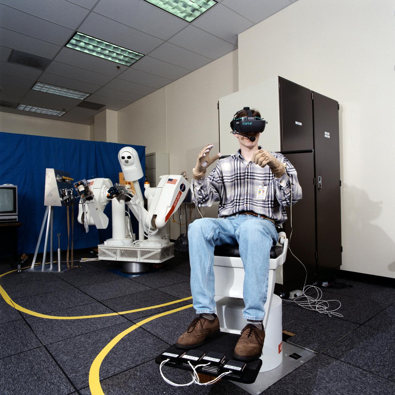 Photographic documentation of the Dextrous Anthropomorphic Robot Testbed (DART)/Full-Immersion Telepresence Testbed (FITT) system. Photos were taken in the Dexterous Robotics Lab, bldg 9N, room 113, and include: DART with upper arm cover removed (08920-1); DART head fully assembled (08922); DART head (08923,08939); DART only official view (08924-5); DART head with shell removed (08926-7); DART/FITT together with operator (08928-9); DART with tools (08930-1,08934); DART with tether hook (08932); DART with rope (08933); DART with Portable Foot Restraint (PFR) (08935); DART pulling out ORU (08936); DART with electronics panel (08937); and DART with automated ball grasp (08938).