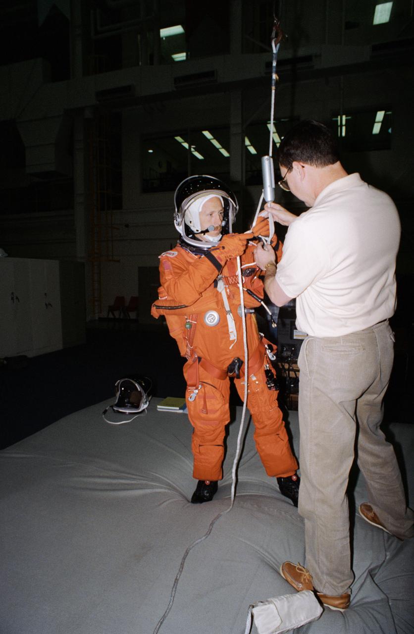S95-09153 (27 Apr. 1995) --- Astronaut Kenneth D. Bowersox has just translated from the top of a Shuttle mockup-trainer using a Sky-genie device during emergency egress training with his six STS-73 crew mates.  He is assisted here by Scott Gill, a member of the STS-73 training staff.  The seven will fly aboard the Space Shuttle Columbia later this year to support the United States Microgravity Laboratory (USML-2) mission.