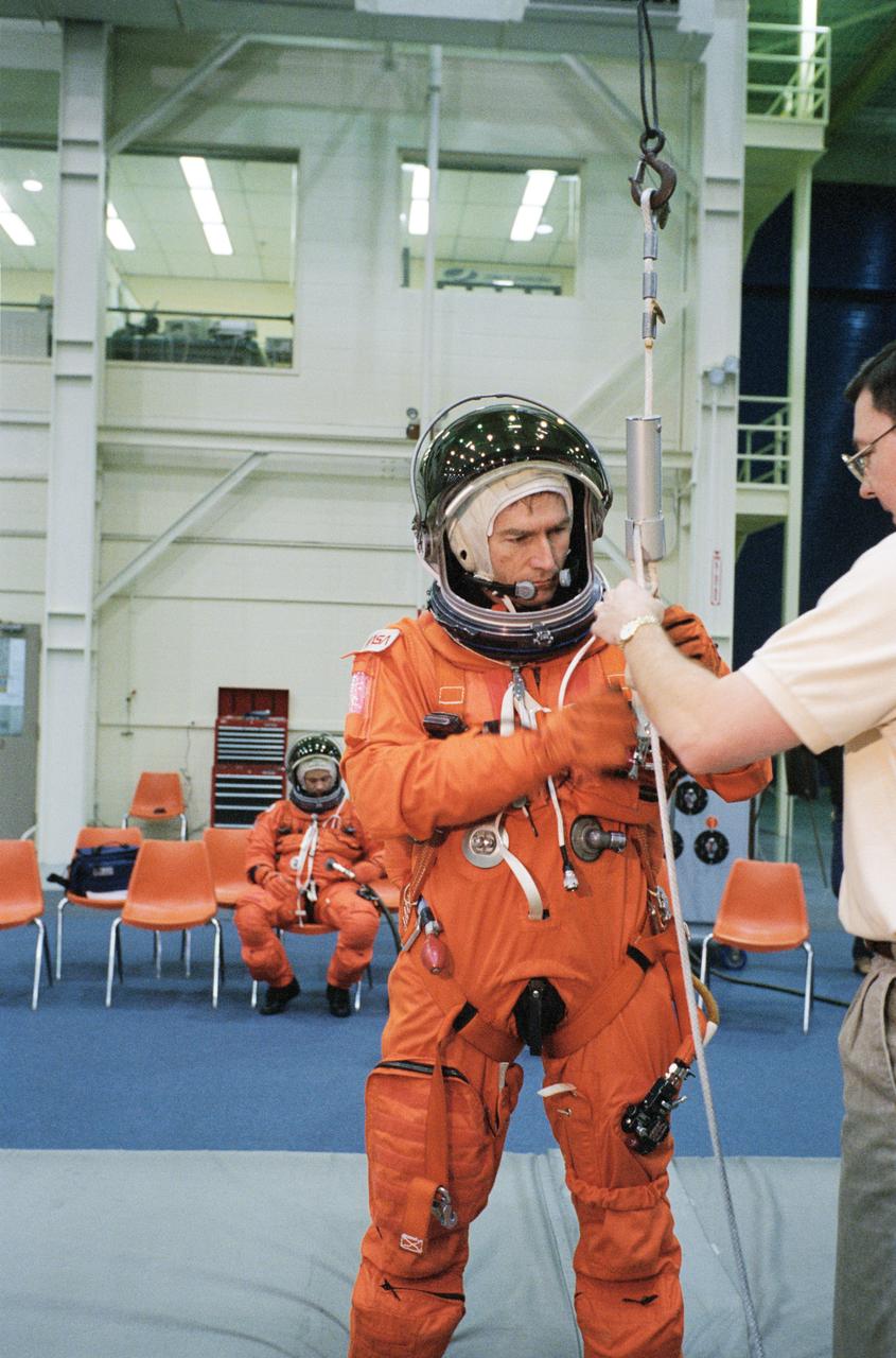 S95-09157 (27 Apr. 1995) --- Payload specialist Fred W. Leslie has just translated from the top of a Shuttle mockup-trainer using a Sky-genie device during emergency egress training with his six STS-73 crew mates.  He is assisted here by Scott Gill, a member of the STS-73 training staff.  The seven will fly aboard the Space Shuttle Columbia later this year to support the United States Microgravity Laboratory (USML-2) mission.