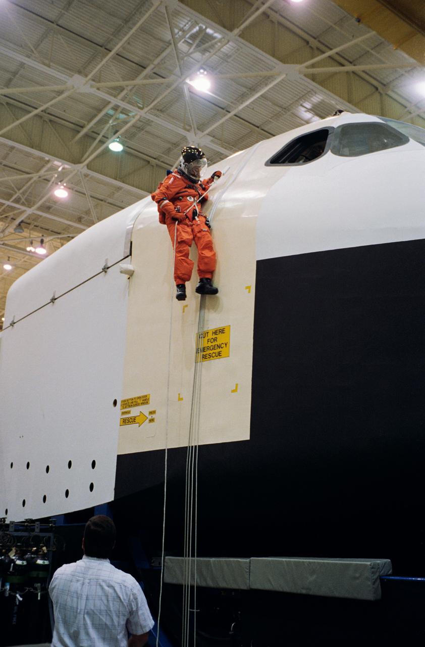 S95-09163 (27 Apr. 1995) --- Payload specialist Albert Sacco Jr. rappels from the top of a Shuttle mockup-trainer using a Sky-genie device during emergency egress training with his six STS-73 crew mates.  The seven will fly aboard the Space Shuttle Columbia later this year to support the United States Microgravity Laboratory (USML-2) mission.