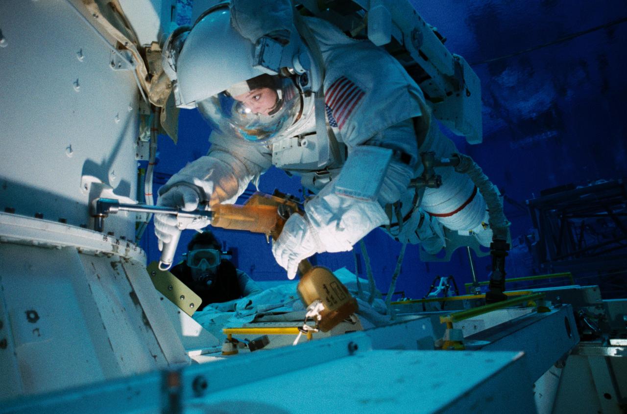 S99-01054 (15 Jan 1999) --- Astronaut Tamara E. Jernigan, mission specialist, uses a special tool during an underwater simulation of a Extravehicular Activity (EVA) scheduled for the mission.  Jernigan was joined by astronaut Daniel T. Barry (out of frame) for the simulation, conducted in the Neutral Buoyancy Laboratory (NBL), at Johnson Space Center?s (JSC) Sonny Carter Training Facility (SCTF).