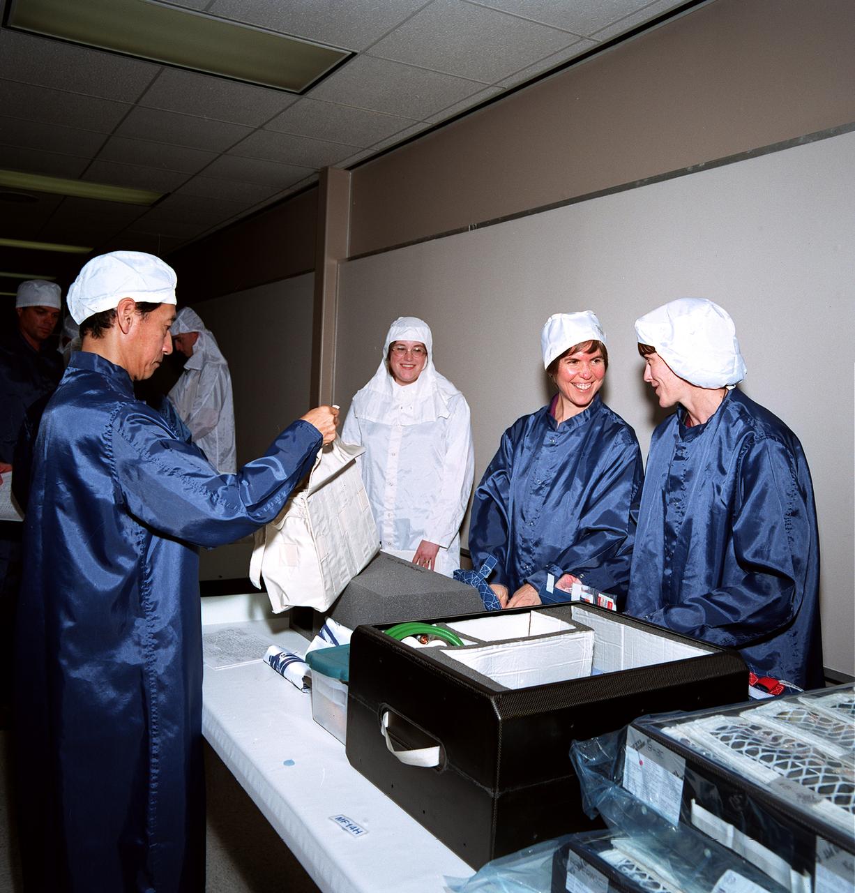 S99-09470 (11 August 1999) --- Three mission specialists participate in a STS-99 flight crew equipment (FCE) bench review.  From the left (in the blue lab coats), astronauts Mamoru Mohri, Janice Voss and Janet L. Kavandi look over equipment and supplies for their assigned mission aboard the Space Shuttle Endeavour later this year. Mohri represents Japan's National Space Development Agency (NASDA). Such bench reviews are routine procedure for crews preparing for shuttle missions.
