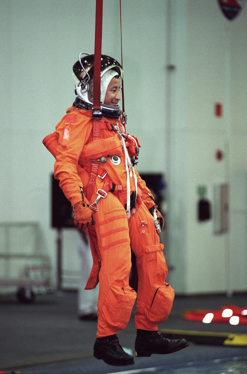 S99-11112 (9 September 1999)--- Equipped with parachute gear, astronaut Edward T. Lu, mission specialist, simulates an emergency egress exercise during a training session at the Neutral Buoyancy Laboratory (NBL) near the Johnson Space Center (JSC). Lu will join four other astronauts and two cosmonauts for a mission next year to the International Space Station (ISS).