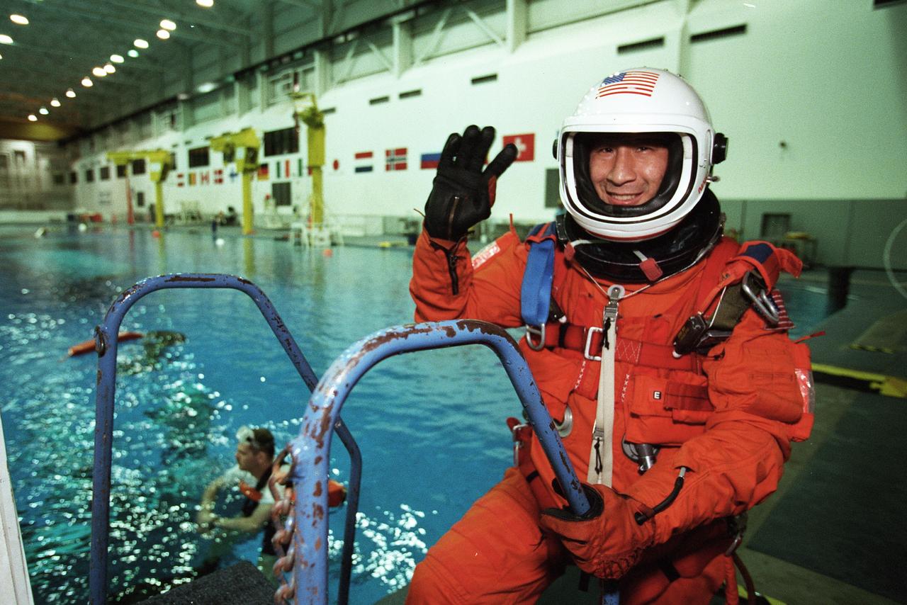 S99-11131 (9 September 1999)--- Wearing a training version of the pressure launch and entry garment, astronaut Edward T. Lu, mission specialist, waves at onlookers during an emergency egress training session at the Neutral Buoyancy Laboratory (NBL) near the Johnson Space Center (JSC). Lu, who moments earlier had simulated a parachute drop into the water, will join four other astronauts and two cosmonauts for one of next year's scheduled missions with the International Space Station (ISS).