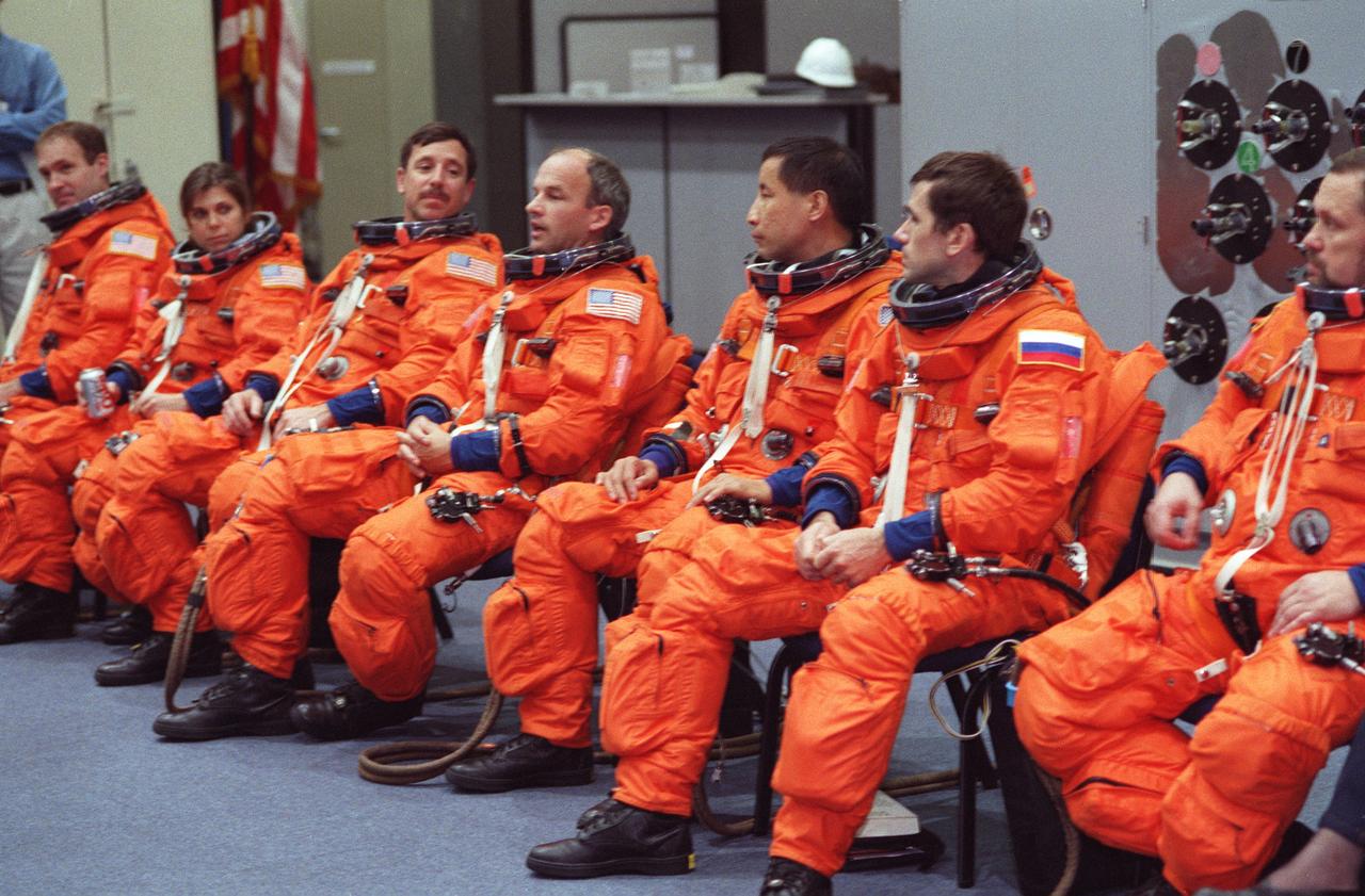 S99-14209 (15 November 1999) --- The seven crew members for STS-101 are seated during a briefing regarding emergency egress procedures. From the left are astronauts James D. Halsell, Jr., Mary Ellen Weber, Scott J. Horowitz, Jeffrey N. Williams and Edward T. Lu, along with cosmonauts Yuri I. Malenchenko and Boris V. Morukov. Malenchenko and Morukov represent the Russian Space Agency (RSA). Editor's Note: Since this photograph was taken, changes in crew personnel have been made. Cosmonauts Yuri I. Malenchenko and Boris V. Morukov, along with astronaut Edward T. Lu were moved to STS-106. Astronauts James S. Voss and Susan J. Helms, and cosmonaut Yury V. Usachev were added to the STS-101 crew. Malenchenko, Morukov and Usachev all represent the Russian Space Agency (RSA).
