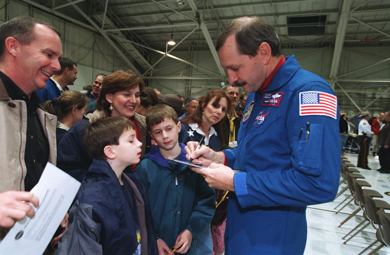 S99-16057 (28 December 1999) --- Astronaut Curtis L. Brown Jr.,misison commander, signs autographs during a crew return ceremony at Ellington Field.