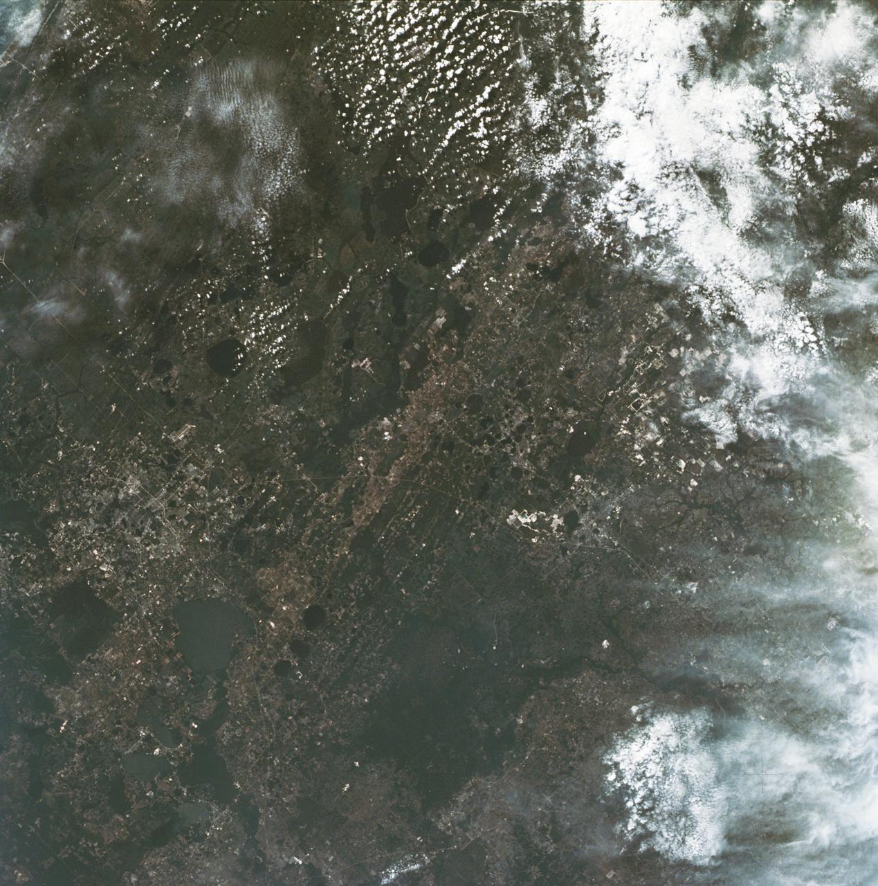 SL2-16-281 (June 1973) --- A vertical view of the Orlando and central Florida area photographed from the Skylab space station in Earth orbit. (The picture should be held with the heaviest cloud cover at the bottom.) The extensive road and highway network in the area is clearly visible. The Lakeland and Winter Haven area is near the center of the picture.  Interstate 4 extends southwesterly out of Orlando through the center of the picture.  The urban growth caused by the opening of the Disney World amusement complex is clearly evident. The giant recreational facility is just southwest of Orlando. This picture was taken by one of the six lenses of the Itek-furnished S190-A Multispectral Photographic Facility Experiment in the Multiple Docking Adapter of the space station. Type SO-356 film was used. Photo credit: NASA