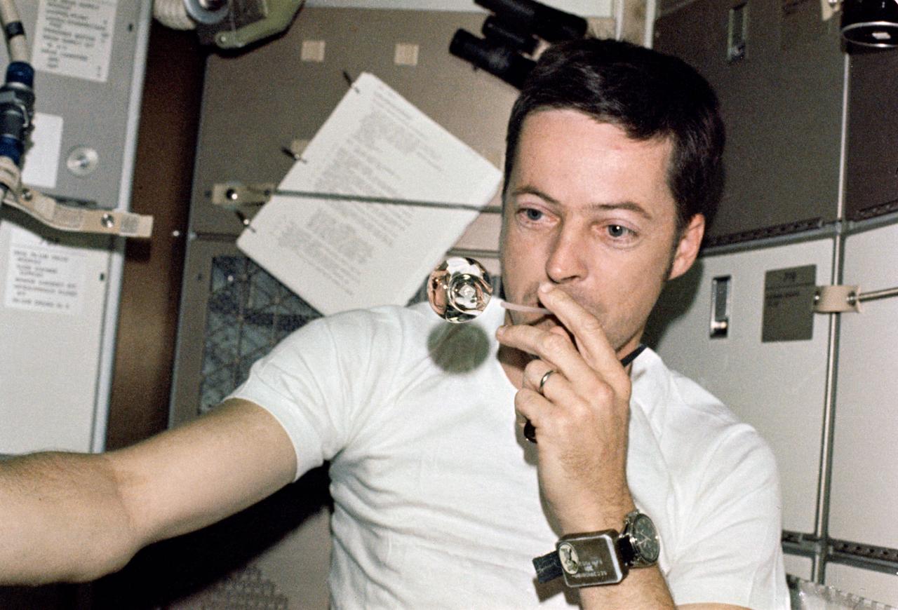 SL2-X9-730 (1 June 1973) --- Scientist-astronaut Joseph P. Kerwin, Skylab 2 science pilot, forms a perfect sphere by blowing water droplets from a straw in zero-gravity. He is in the crew quarters of the Skylab Orbital Workshop. Photo credit: NASA