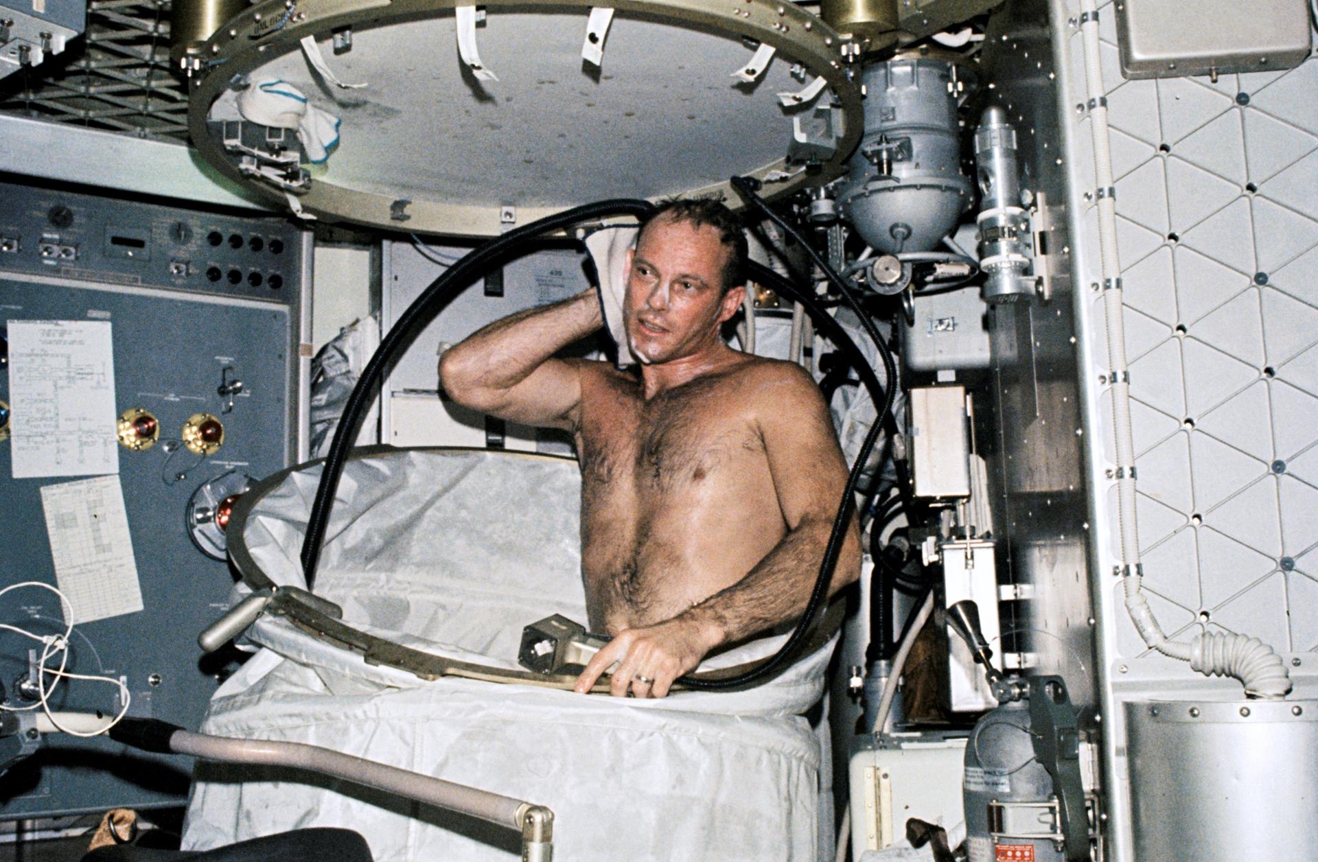 Jack Lousma takes a shower in the shower facility on the Skylab space station.