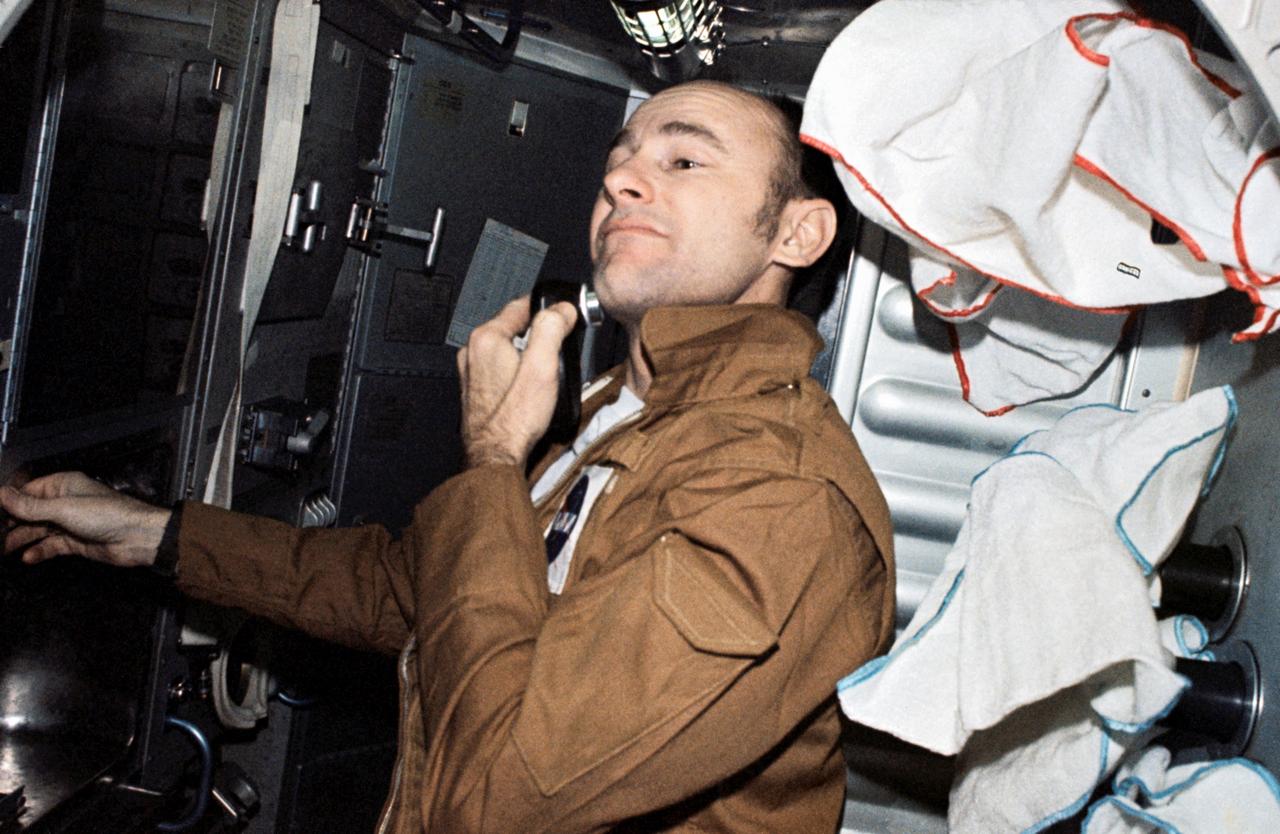 SL3-111-1516 (July-September 1973) --- Astronaut Alan L. Bean, Skylab 3 commander, uses a battery powered shaver in the crew quarters of the Orbital Workshop (OWS) aboard the Skylab space station cluster in Earth orbit. Astronaut Bean, Owen K. Garriott, science pilot, and Jack R. Lousma, pilot, went on to successfully complete 59 days aboard the Skylab cluster in Earth orbit. Photo credit: NASA