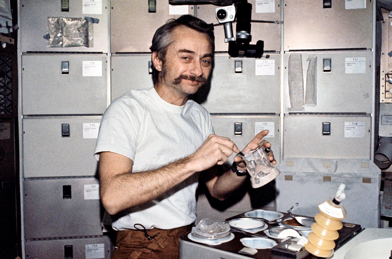 SL3-111-1519 (6 Aug. 1973) --- Scientist-astronaut Owen K. Garriott, Skylab 3 science pilot, reconstitutes a pre-packaged container of food at the crew quarters ward room table of the Orbital Workshop (OWS) of the Skylab Space Station cluster. This picture was taken with a hand-held 35mm Nikon camera.  Astronauts Garriott, Alan L. Bean and Jack R. Lousma remained with the Skylab Space Station in Earth orbit for a total of 59 days conducting numerous medical, scientific and technological experiments. Note the knife and fork on the food tray and the utensil with which Garriott stirs the food mixed with water. Skylab is the first manned space program by NASA which affords the crew men an opportunity to eat with the same type utensils used on Earth. Photo credit: NASA