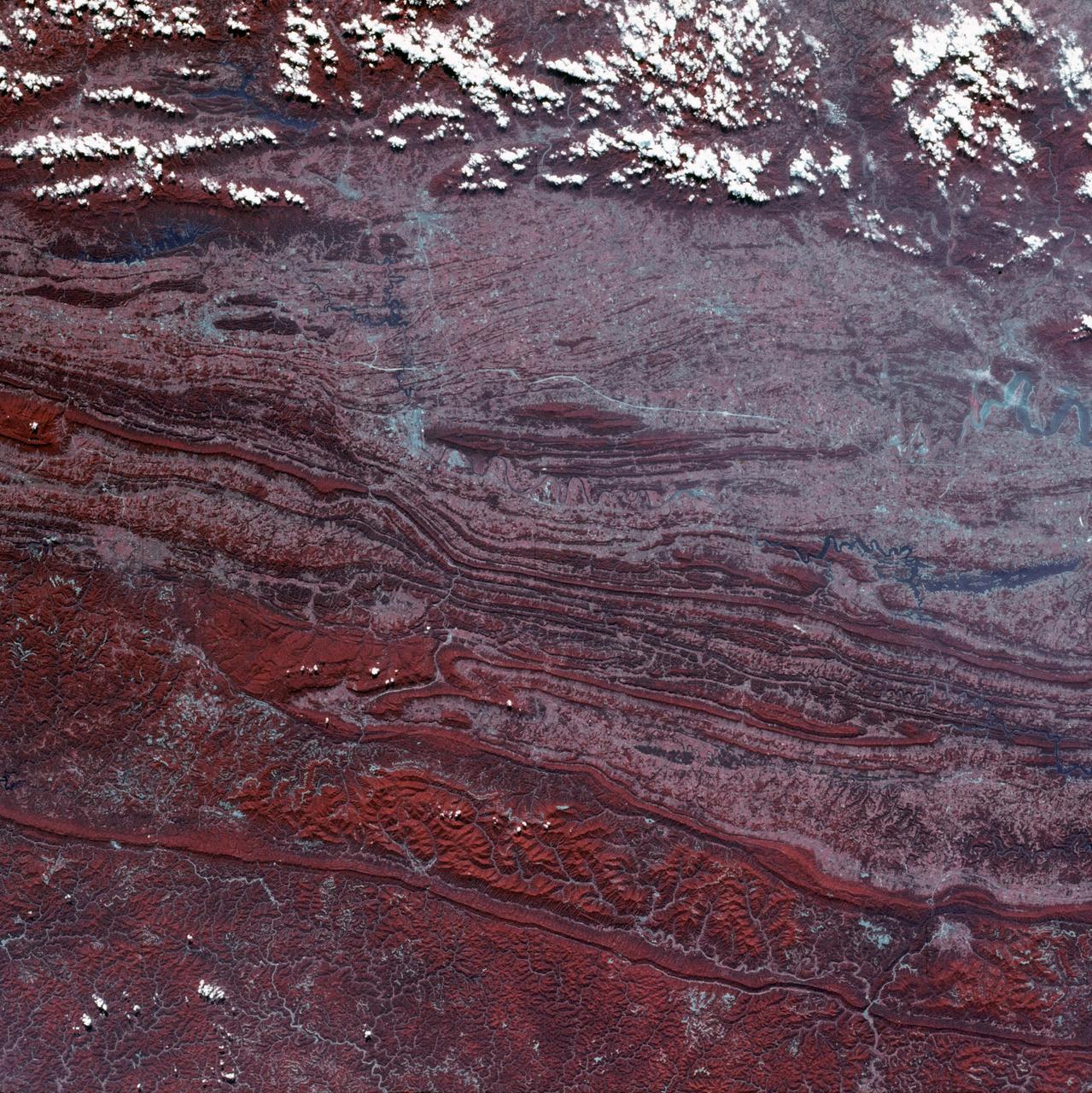 SL3-45-020 (July-September 1973) --- A vertical view of the Virginia-Tennessee-Kentucky border area as photographed from Earth orbit by one of the six lenses of the Itek-furnished S190-A Multispectral Photographic Facility Experiment aboard the Skylab space station. This picture was taken with type 2443 infrared color film. The S190-A experiment is part of the Skylab Earth Resources Experiments Package. The long, narrow ridge is Pine Mountain; and it is crossed by U.S. 25E at Pineville near its southernmost end. Some 25 miles south of Pineville U.S. 25E passes through the famed Cumberland Gap which at 1,600 feet elevation crosses Cumberland Mountain. Kingsport, Tennessee is located east of Cumberland Gap near the center of the picture. Bristol, Tennessee-Virginia is further east.  Greenville and Elizabethton, Tennessee can also be seen in this photograph. The clouds across the southeast edge of the picture are over the Blue Ridge Mountains. Federal agencies participating with NASA on the EREP project are the Departments of Agriculture, Commerce, Interior, the Environmental Protection Agency and the Corps of Engineers.  All EREP photography is available to the public through the Department of Interior?s Earth Resources Observations Systems Data Center, Sioux Falls, 57198. Photo credit: NASA