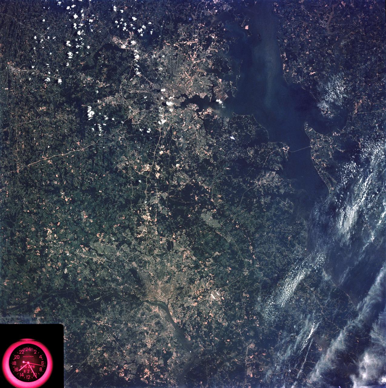 SL3-83-166 (July-September 1973) --- A vertical view of the Washington D.C. and the Baltimore, Maryland area is seen in the Skylab 3 Earth Resources Experiments Package S190-B (five-inch Earth terrain camera) photograph taken from the Skylab space station in Earth orbit. The Chesapeake Bay is on the right (east) side of the picture. The Potomac River flows through the Washington area in the lower left (southwest) corner of the photograph.  Several transportation routes and major highways stand out very distinctly. Especially conspicuous are the beltways around the cities, Interstate 95 between Baltimore and the nation?s capitol and Interstate 70N leading west from Baltimore. The tunnel and harbor facilities in Baltimore show clearly, also. Identifiable features in the Washington area include the Capitol Building, the Mall area, Robert F. Kennedy Stadium (white circle), the five bridges across the Potomac, Andrews Air Force Base (on east loop), and the smaller Anacostia River. The extent of the urbanization in this area is dramatically illustrated in this picture. The photograph has sufficient resolution that the housing patterns for individual suburban areas are clearly defined with the houses shown as pink gray, wooded areas as dark green and cleared areas light green. Chesapeake Bay circulation patterns are indicated by contrast of dark and light blue. Sediment plumes (red) are seen entering the bay north and east of Baltimore.  The bay bridge stands out white against the blue water. The detailed information contained in this one photograph will be of direct use to several EREP investigator teams in land use analysis, sedimentation and circulation patterns in the bay, and resource surveys of Maryland. All EREP photography is available to the public through the Department of Interior?s Earth Resources Observations Systems Data Center, Sioux Falls, South Dakota, 57198. Photo credit: NASA