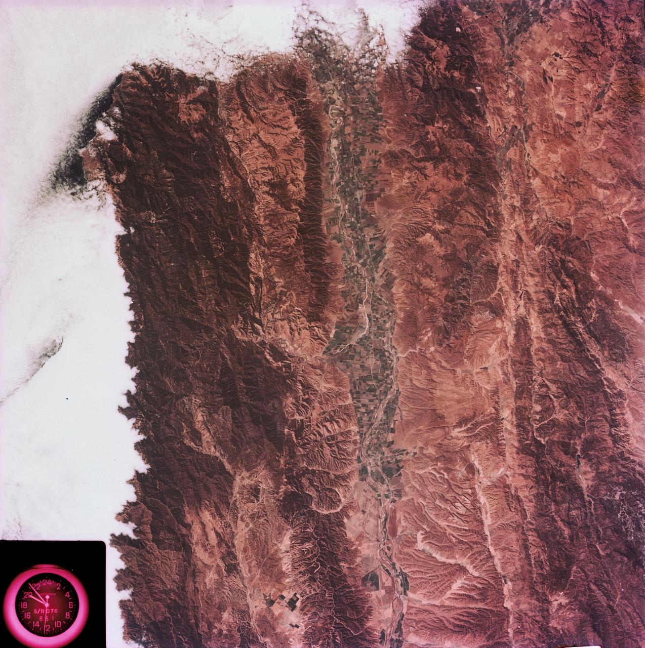 SL3-88-004 (July-September 1973) --- A vertical view of the Salinas River Valley area south of Monterey Bay, California area is seen in this Skylab 3 Earth Resources Experiments Package S190-B (five-inch Earth terrain camera) photograph taken from the Skylab space station in Earth orbit. The valley is an irrigated agricultural area, and is indicated by the dark-green and light-gray rectangular patterns in the centre of the picture. The city of Salinas is barely visible under the cloud cover at the top (north) end of the valley. The dark mass on the left (west) side of the valley is the Santa Lucia mountain range. The Big Sur area is on the left and partly covered by clouds. The Diablo Range forms the dark mass in the lower right (southeast) corner of the photograph. The town of Hollister is the gray area in the dark-green rectangular farm tracts which occupy the floor of the San Benito Valley in the upper right (northeast) corner of the photograph.  The Salinas River flows northwestward toward Monterey Bay. The towns of Soledad, Greenfield and King City appear as gray areas along U.S. 101 in the Salinas Valley. The geology of the area is complex, and has been racked by several earthquakes resulting from movement along the San Andreas and subsidiary faults.  Here, the surface expression of the San Andreas Fault can be traced from a point just west of Hollister at the contrast of dark brown and tan to a point about one inch left of the lower right (southeast) corner of the picture. Subsidiary faults are indicated by the curving trend of the rocks along the right side. The photograph will provide detailed information on land use patterns (Dr. R. Colwell, University of California, Berkeley) and fault tectonics (Dr. P. Merifield, Earth Science Res., Inc. and Dr. M. Abdel-Gawad, Rockwell International). Federal agencies participating with NASA on the EREP project are the Departments of Agriculture, Commerce, Interior, the Environmental Protection Agency and the Corps of Engineers. All EREP photography is available to the public through the Department of Interior’s Earth Resources Observations Systems Data Center, Sioux Falls, South Dakota, 57198. Photo credit: NASA