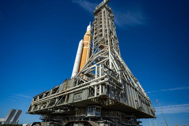 This image shows NASA’s SLS (Space Launch System) and Orion spacecraft rollin...