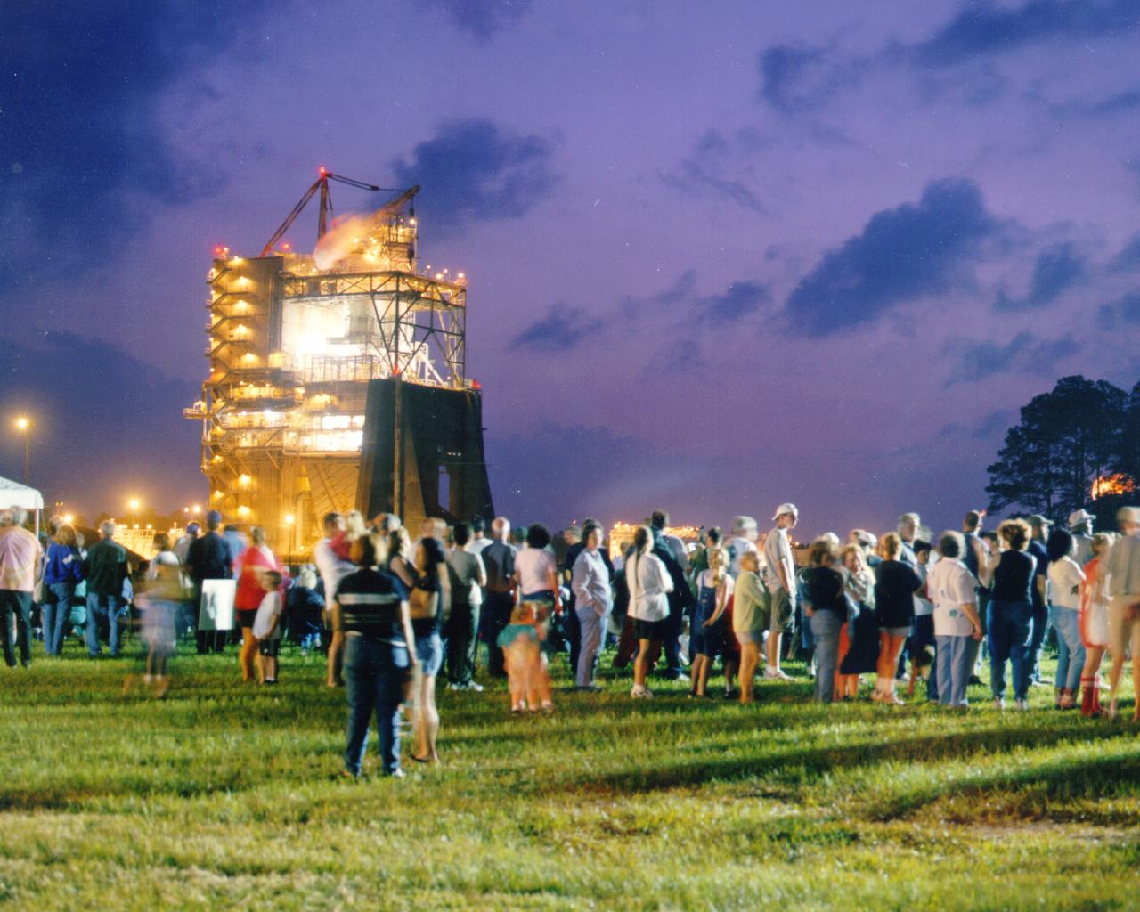 Approximately 13,000 people fill the grounds at NASA's John C. Stennis Space Center for the first-ever evening public engine test of a Space Shuttle Main Engine. The test marked Stennis Space Center's 20th anniversary celebration of the first Space Shuttle mission.