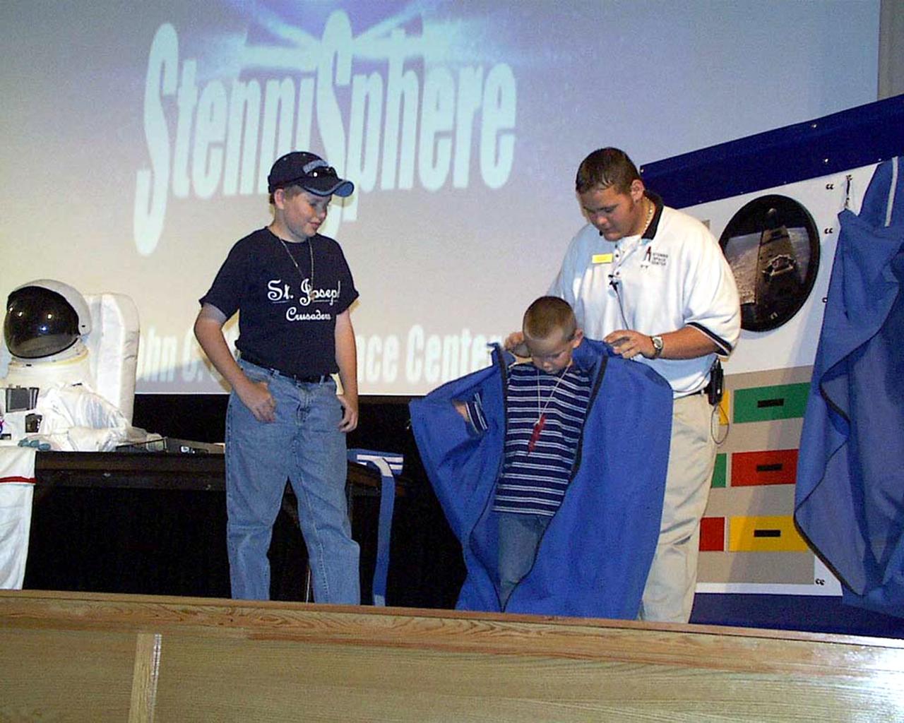 Students try on a sleep restraint like the ones used by astronauts. This demonstration is part of a program called 'Living and Working in Space,' that is presented by NASA's Stennis Space Center in the StenniSphere Auditorium and in the community.