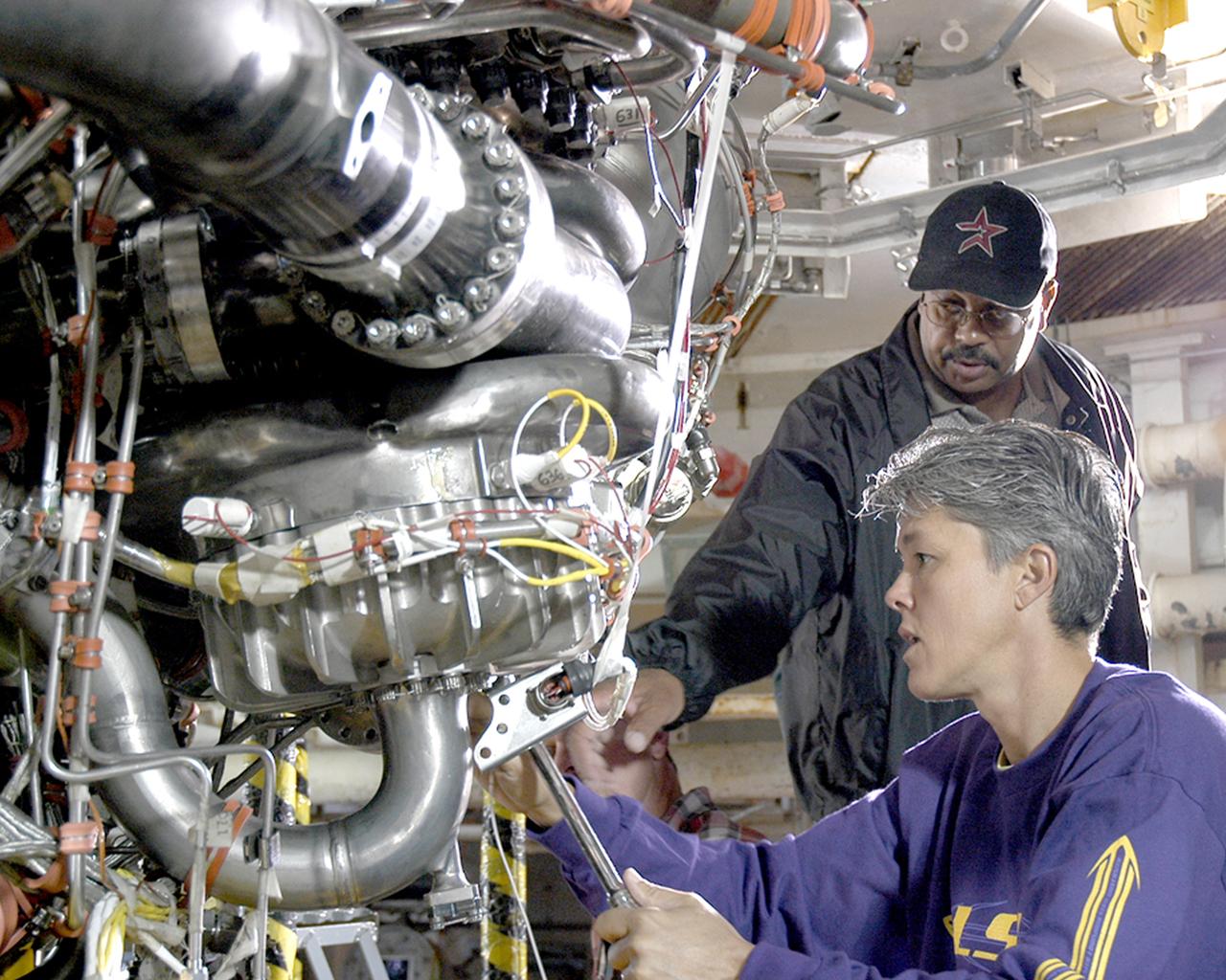 Alvin Pittman Sr., lead electronics technician with Pratt & Whitney Rocketdyne, and Janine Cuevas, a mechanical technician with PWR, perform final preparations on the space shuttle main engine tested Oct. 25, 2005, at NASA's Stennis Space Center. It was the first main engine test since Hurricane Katrina hit the Gulf Coast on Aug. 29.