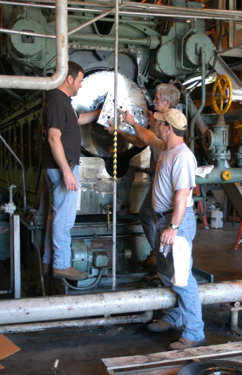 NASA Test Operations Group employees, from left, Todd Pearson, Tim Delcuze and Rodney Wilkinson maintain a water pump in Stennis Space Center's high-pressure water facility. The three were part of a group of employees who rode out Hurricane Katrina at the facility and helped protect NASA's rocket engine test complex.