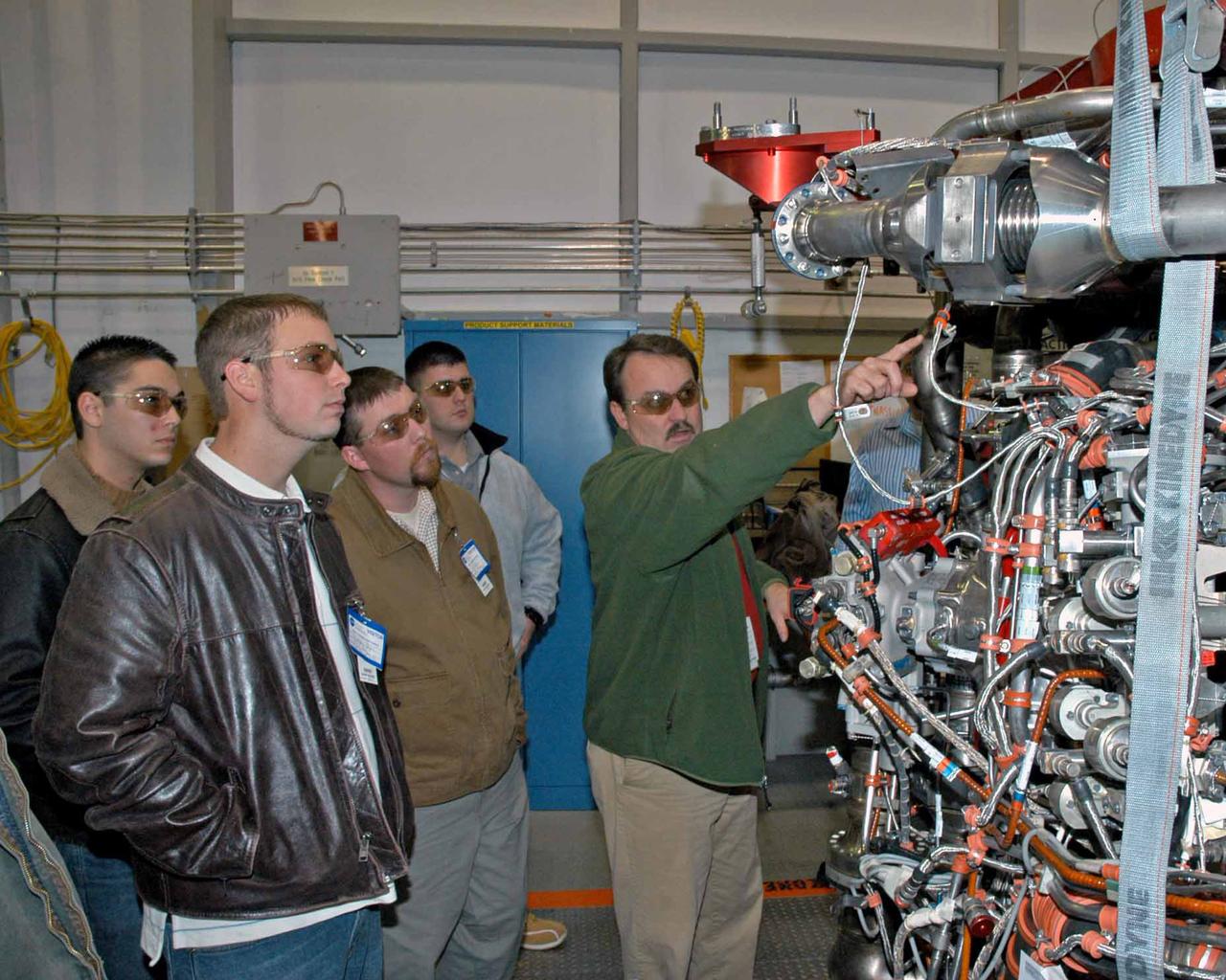 Pratt & Whitney Rocketdyne's Jeff Hansell, right, explains functions of a space shuttle main engine to Pearl River Community College Aviation Maintenance Technology Program students. Christopher Bryon, left, of Bay St. Louis, Ret Tolar of Kiln, Dan Holston of Baxterville and Billy Zugg of Long Beach took a recent tour of the SSME Processing Facility and the E-1 Test Complex at Stennis Space Center in South Mississippi. The students attend class adjacent to the Stennis International Airport tarmac in Kiln, where they get hands-on experience. PRCC's program prepares students to be responsible for the inspection, repair and maintenance of technologically advanced aircraft. A contractor to NASA, Pratt & Whitney Rocketdyne in Canoga Park, Calif., manufactures the space shuttle main engine and its high-pressure turbo pumps. SSC was established in the 1960s to test the huge engines for the Saturn V moon rockets. Now 40 years later, the center tests every main engine for the space shuttle, and is America's largest rocket engine test complex. SSC will soon begin testing the rocket engines that will power spacecraft carrying Americans back to the moon and on to Mars.
