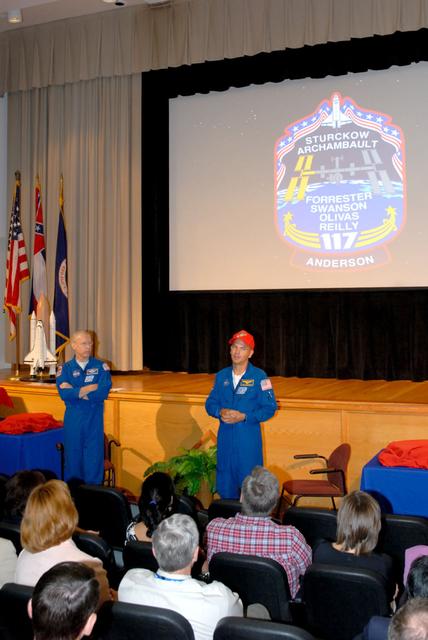 Astronauts Rick Sturckow (right) and Pat Forrester make a presentation Aug. 2 at NASA Stennis Space Center near Bay St. Louis, Miss., about their recent space shuttle mission, STS-117. Sturckow and Forrester thanked employees for the reliability and safe performance of the space shuttle's main engines, which are all tested and proved flight-worthy at SSC. The astronauts delivered a video of their mission's highlights, held a question-and-answer session, met one-on-one with employees and presented two Silver Snoopy awards during their visit. The STS-117 mission, which launched June 8, delivered a truss segment and a set of U.S. solar arrays, batteries and associated equipment to the International Space Station. Sturckow commanded the mission; Forrester was a mission specialist who performed two of STS-117's four spacewalks.