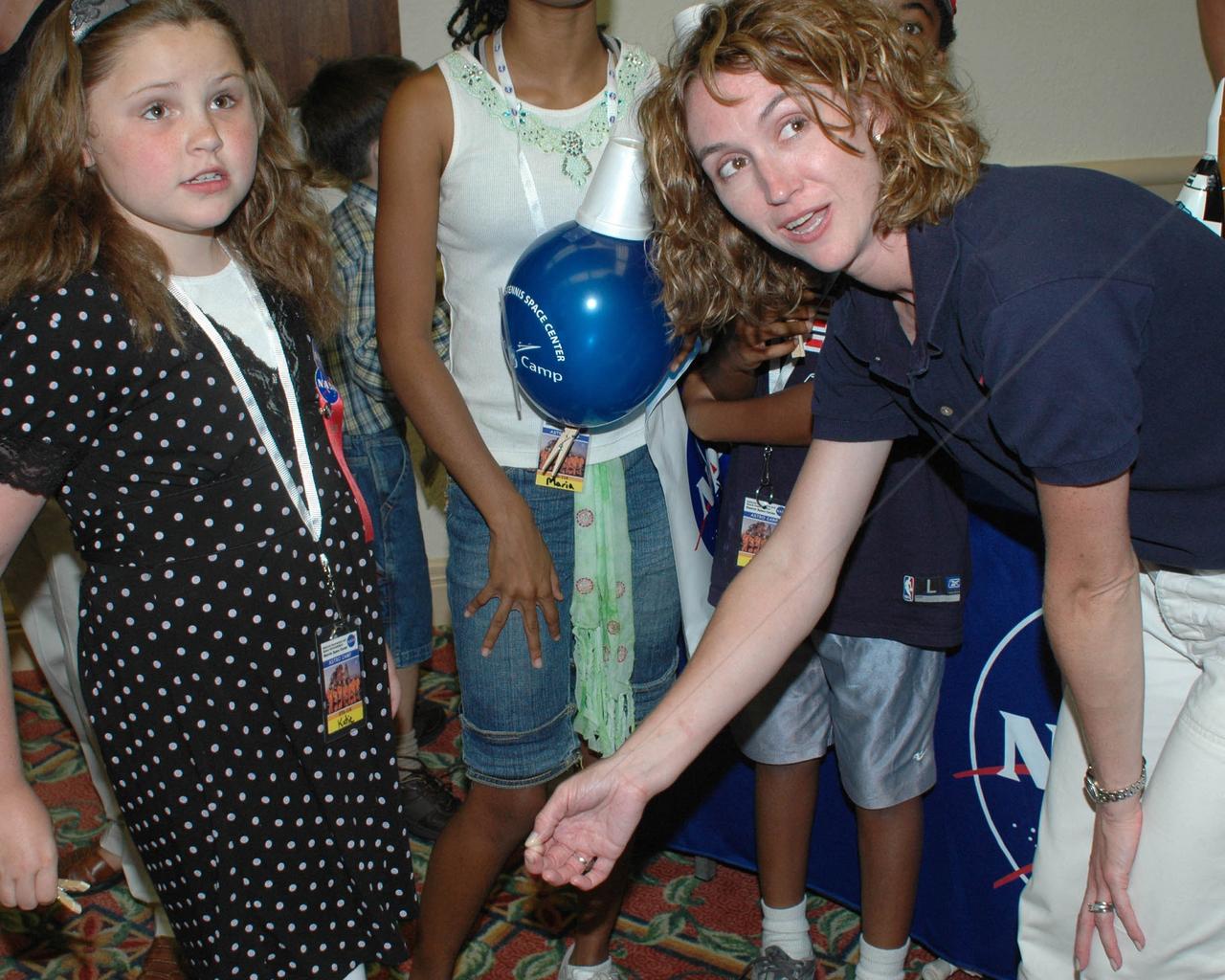 Katie Craig, daughter of former Stennis Space Center Deputy Director Mark Craig, launches a 'balloon rocket' with the help of Rebecca Compretta, Astro Camp coordinator at SSC. SSC took Astro Camp on the road to Florida this week to engage children and their parents during activities surrounding the Aug. 8 launch of Space Shuttle Endeavour on NASA's STS-118 mission to the International Space Station. Astro Camp is SSC's popular space camp program designed to inspire and educate students using science and math principles.