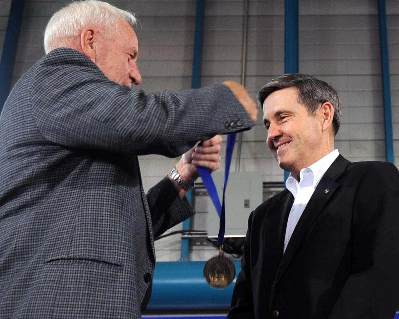 Former astronaut Al Worden (left) presents Stennis Space Center Director Bob Cabana with a gold medallion signifying his induction into the U.S. Astronaut Hall of Fame at Kennedy Space Center in Florida.