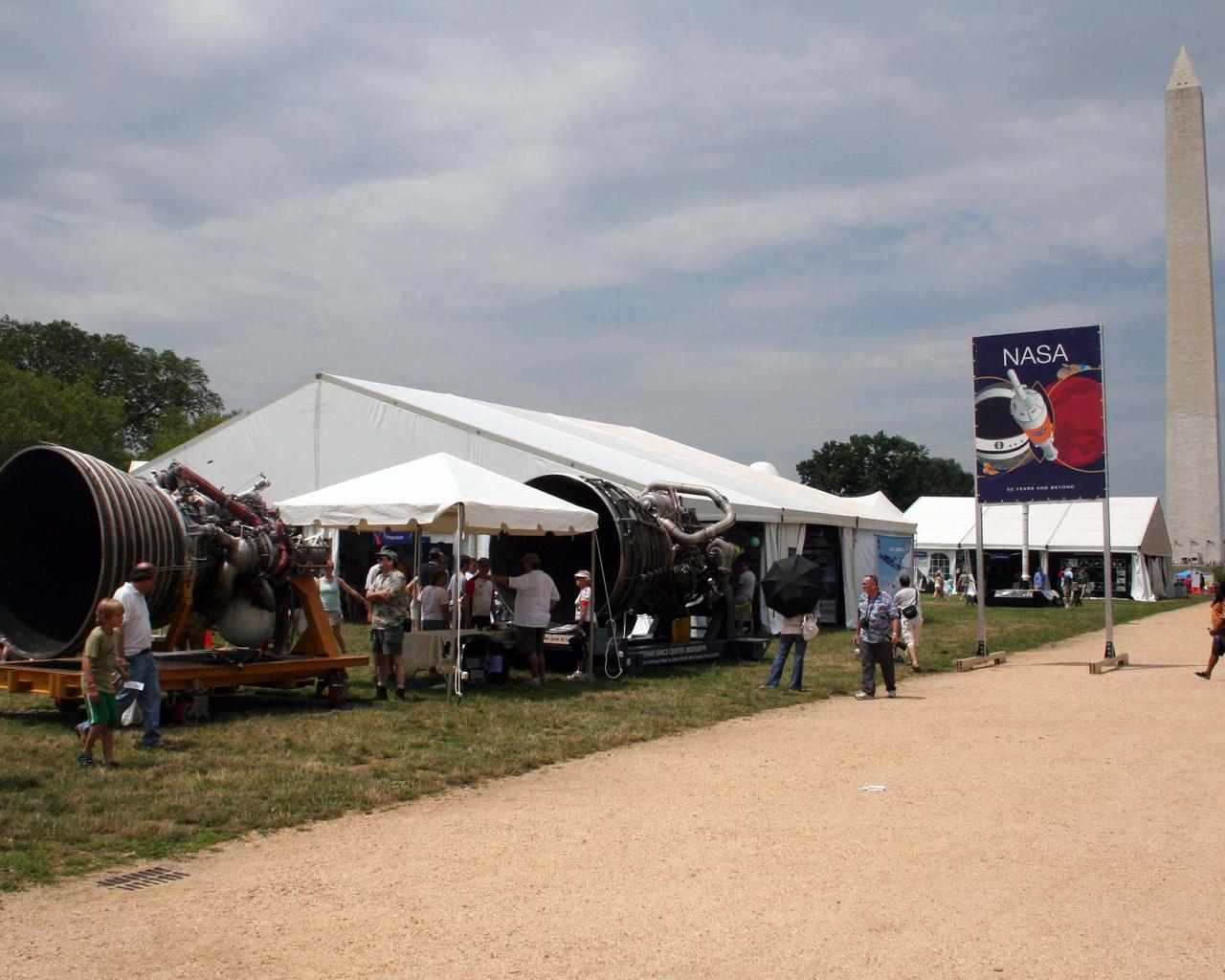 With the Washington Monument as a stirring background, a space shuttle main engine and J-2 engine from Stennis Space Center offer Washington Mall visitors a close-up look at the power of spaceflight