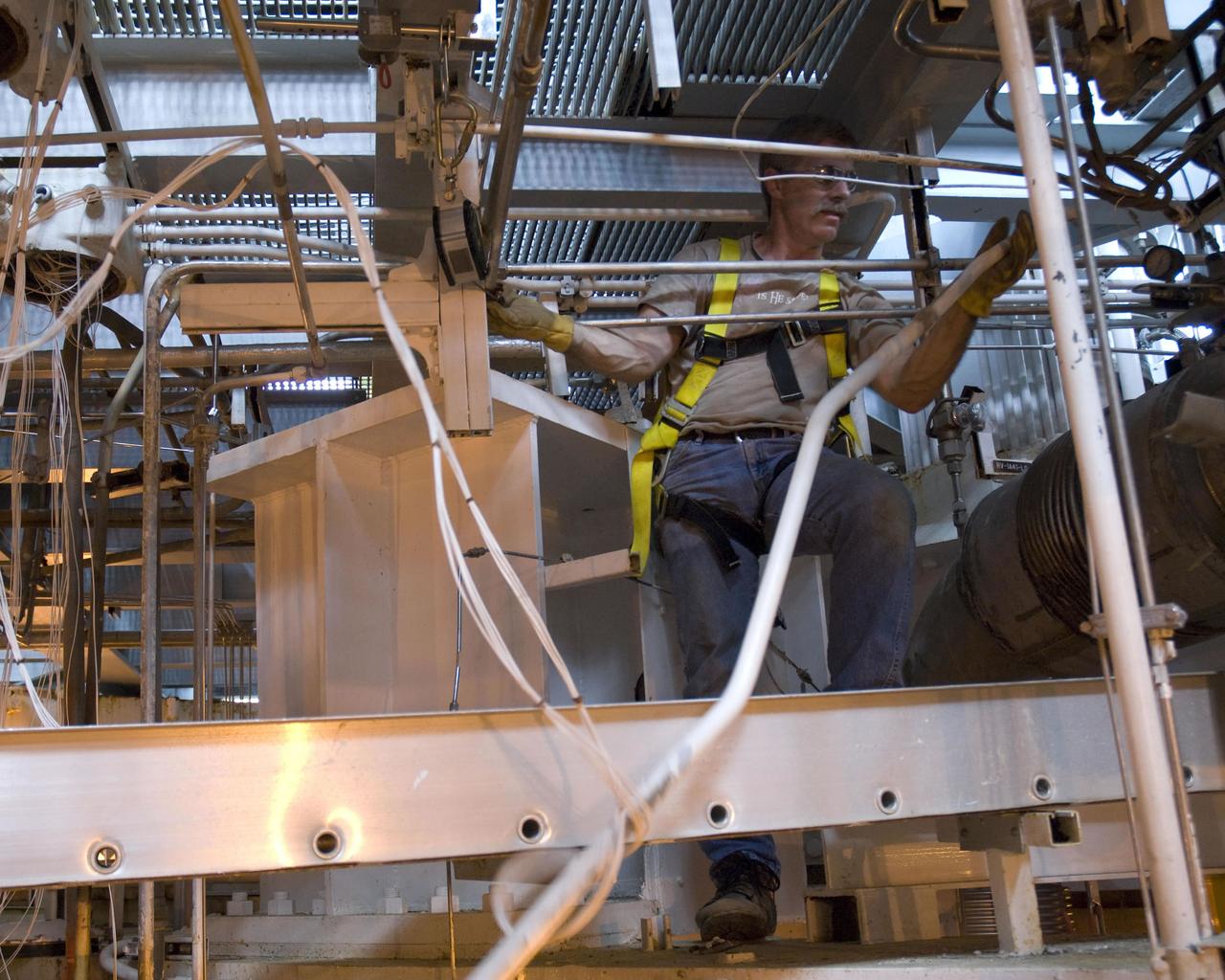 Phil Schemanski of Pratt & Whitney Rocketdyne removes equipment inside the thrust drum on the A-1 Test Stand as part of a comprehensive modification project to prepare for testing the new J-2X engine.