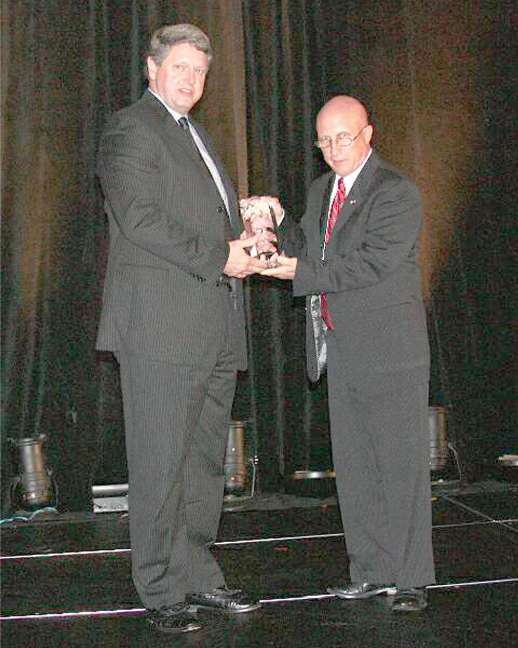Gene Goldman (left), deputy director of NASA's John C. Stennis Space Center, accepts an Award of Excellence from Jack Zink, executive director of the Hancock County Port and Harbor Commission, during the 2008 Annual Hancock County Awards Gala. The Award of Excellence was presented to recognize Stennis Space Center's contribution to NASA's 50 years of excellence in space exploration.