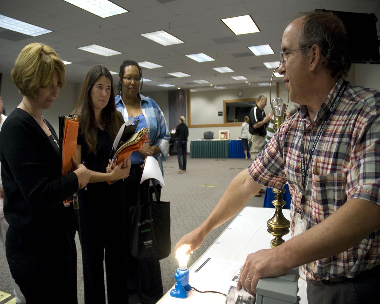 Donnie Thompson, site energy manager for the Jacobs Technology FOSC Group, demonstrates the efficiency of fluorescent bulbs during Energy Awareness Day at Stennis on Sept. 30.