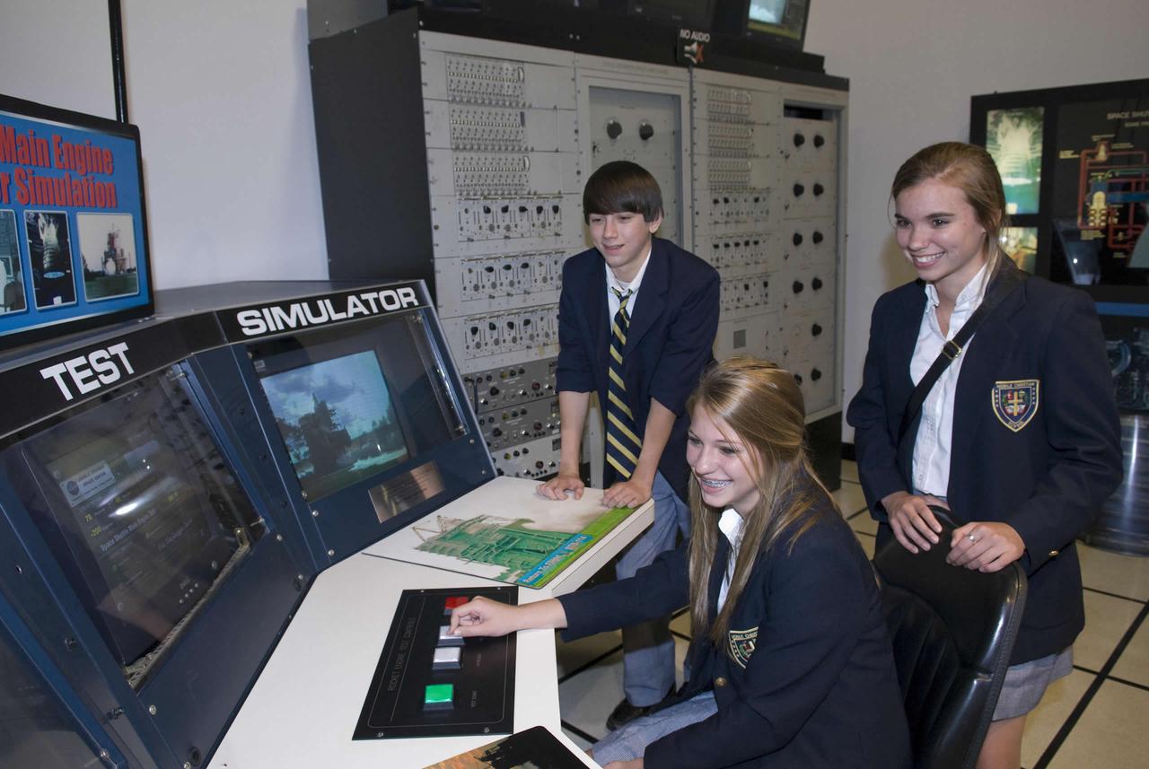 Louis Stork, 13, and Erin Whittle, 14, look on as Brianna Johnson, 14, conducts a 'test' of a space shuttle main engine in the Test Control Center exhibit in StenniSphere, the visitor center at NASA's John C. Stennis Space Center near Bay St. Louis, Miss. The young people were part of a group from Mobile Christian School in Mobile, Ala., that visited StenniSphere on April 21.