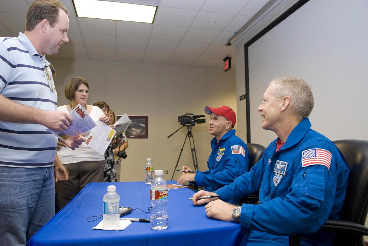 Astronauts C.J. Sturckow (seated, left) and Pat Forrester (seated, right) sign autographs during their Oct. 7 visit to Stennis Space Center. The astronauts visited the rocket engine testing facility to thank Stennis employees for contributions to their recent STS-128 space shuttle mission. All three of the main engines used on the mission were tested at Stennis. Sturckow served as commander for the STS-128 flight; Forrester was a mission specialist. During a 14-day mission aboard space shuttle discovery, the STS-128 crew delivered equipment and supplies to the International Space Station, including science and storage racks, a freezer to store research samples, a new sleeping compartment and an exercise treadmill. The mission featured three spacewalks to replace experiments and install new equipment at the space station.
