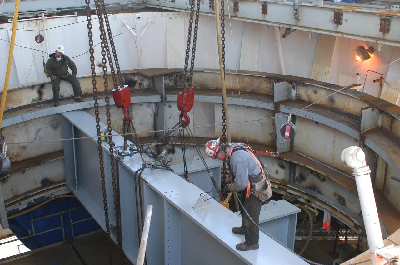 Employees at NASA's John C. Stennis Space Center work to maneuver a structural steam beam into place on the A-1 Test Stand on Jan. 13. The beam was one of several needed to form the thrust takeout structure that will support a new thrust measurement system being installed on the stand for future rocket engine testing. Once lifted onto the stand, the beams had to be hoisted into place through the center of the test stand, with only two inches of clearance on each side. The new thrust measurement system represents a state-of-the-art upgrade from the equipment installed more than 40 years ago when the test stand was first constructed.