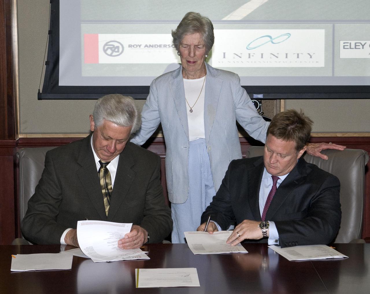 Key state and community leaders celebrated April 6 with the signing of a construction contract for the state-of-the-art INFINITY Science Center planned near John C. Stennis Space Center in south Mississippi. Gulfport Mayor George Schloegel (l to r), chair of non-profit INFINITY Science Center Inc., was joined for the signing ceremony at the Hancock Bank in Gulfport by Virginia Wagner, sister of late Hancock Bank President Leo Seal Jr.; and Roy Anderson III, president and CEO of Roy Anderson Corp. Seal was the first chair of INFINITY Science Center Inc., which has led in development of the project. Roy Anderson Corp. plans to begin construction on the 72,000-square-foot, $28 million science and education center in May. The Mississippi Department of Transportation (MDOT) also is set to begin construction of a $2 million access road to the new center. The April 6 ceremony was attended by numerous officials, including former Stennis Space Center Directors Jerry Hlass and Roy Estess; Mississippi Senate President Pro Tempore Billy Hewes, R-Gulfport; Mississippi Rep. Diane Peranich, D-Pass Christian; and MDOT Southern District Commissioner Wayne Brown.