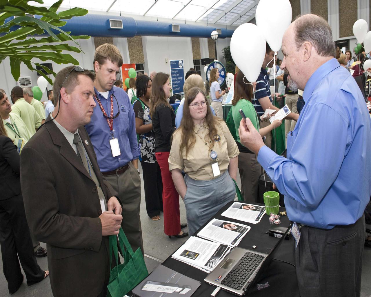 Brian Wagner (l to r) with the U.S. Navy, Andrew Hiukenbein with NVision Solutions and Theresa Avoskey with the Naval Oceanographic Office at Stennis Space Center learn about the latest improvements in making flash drives secure during an Information Technology Expo held June 16. Various area companies visited Stennis during the day to offer exhibits for employees on a range of information technology topics. The theme of the daylong expo was 'The Road to Green IT Computing.'