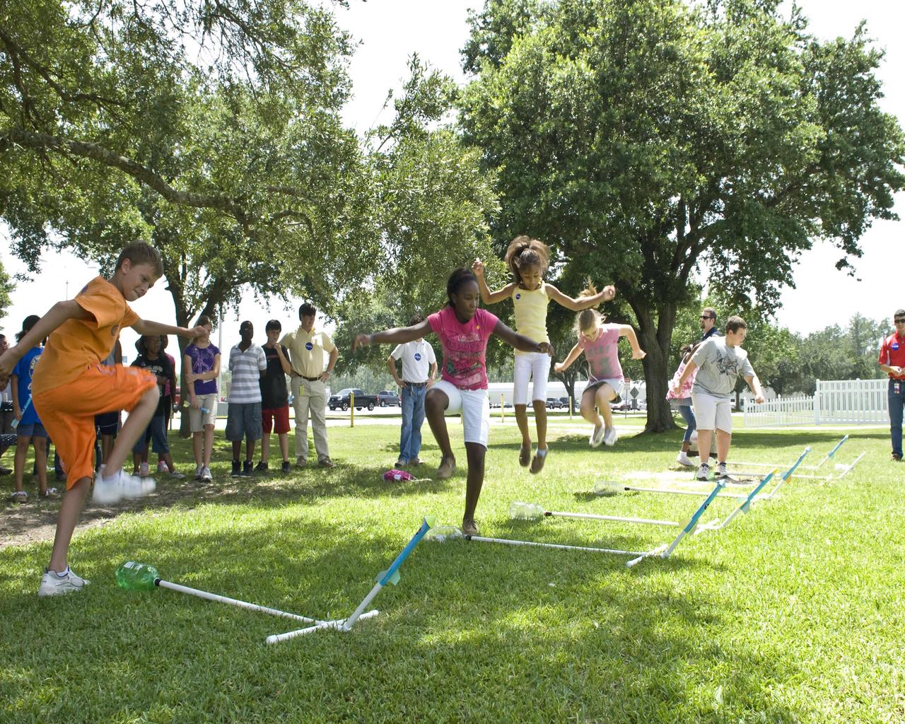 Young visitors to NASA's John C. Stennis Space Center prepare to launch 'stomp rockets' during STEM-Ulate to Innovate activities at the facility July 13. The NASA Foundations of Influence, Relationships, Success and Teamwork (FIRST) Team sponsored STEM-Ulate to Innovate for more than 100 children ages 9-11. Children from area Boys & Girls Clubs participated in hands-on activities, presentations and demonstrations by professional engineers, all designed to promote the relevance of science, technology, engineering and mathematics (STEM).
